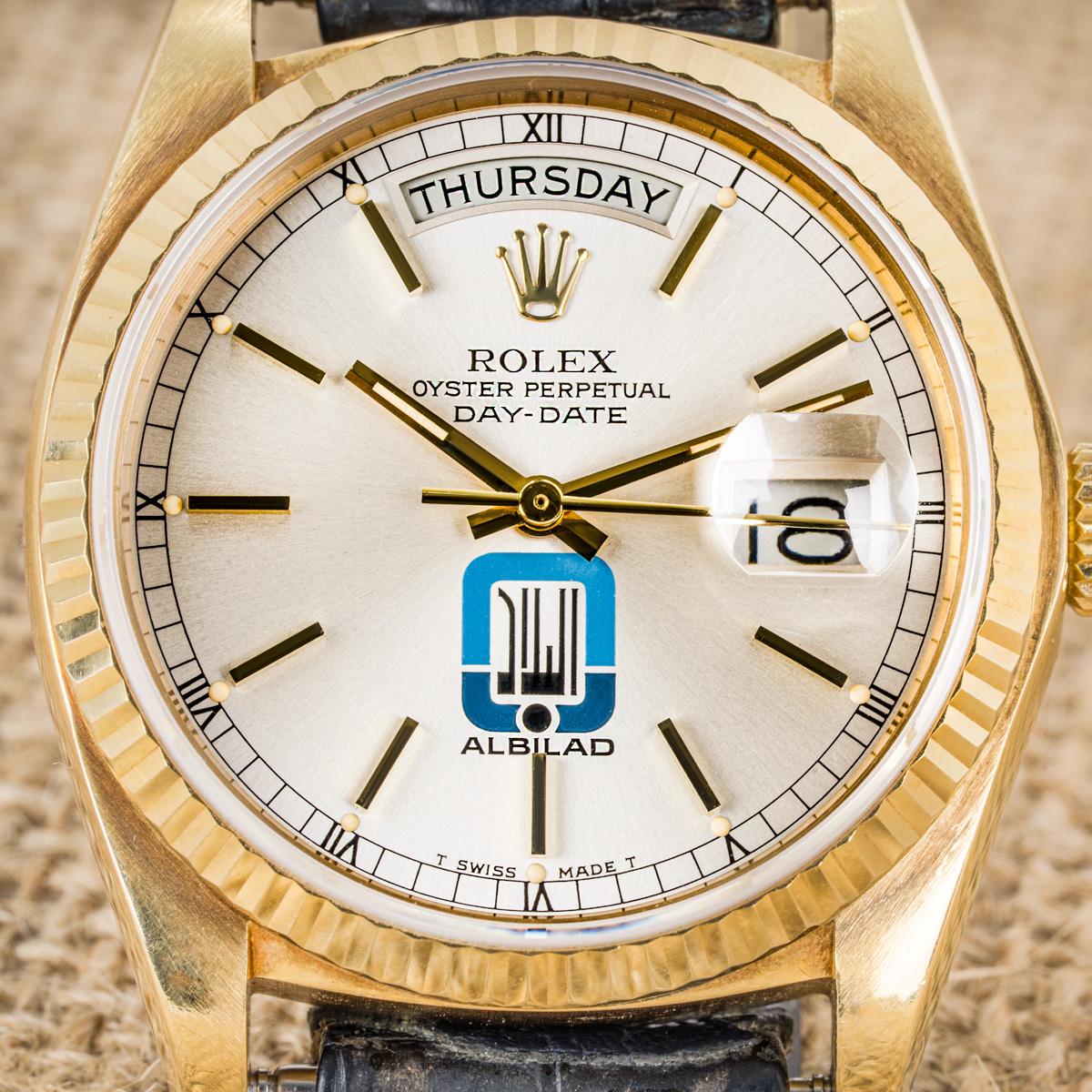 A Rolex Day-Date 36mm crafted in yellow gold by Rolex. Featuring a champagne dial with a distinctive logo of the Albilad Fire Fighting Systems company from Saudi Arabia. Complementing the dial is a yellow gold fluted bezel and a screw-down