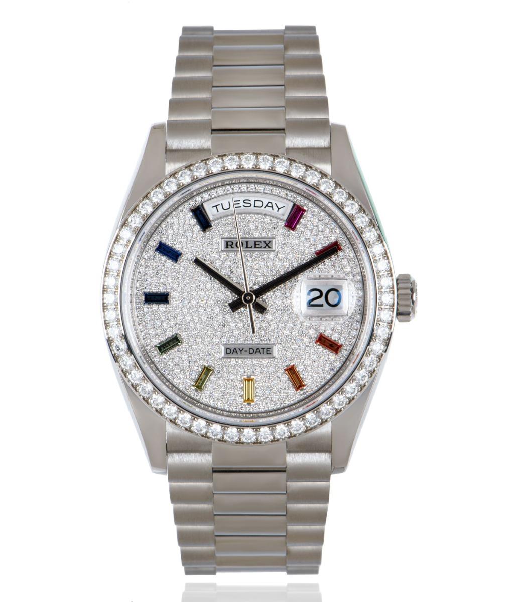 Eine 36-mm-Day-Date 36 aus Weißgold von Rolex mit diamantbesetztem Zifferblatt und 10 regenbogenfarbenen Saphir-Indizes. Außerdem ist die Lünette mit 52 runden Diamanten im Brillantschliff besetzt. Das Präsidentenarmband und die verdeckte