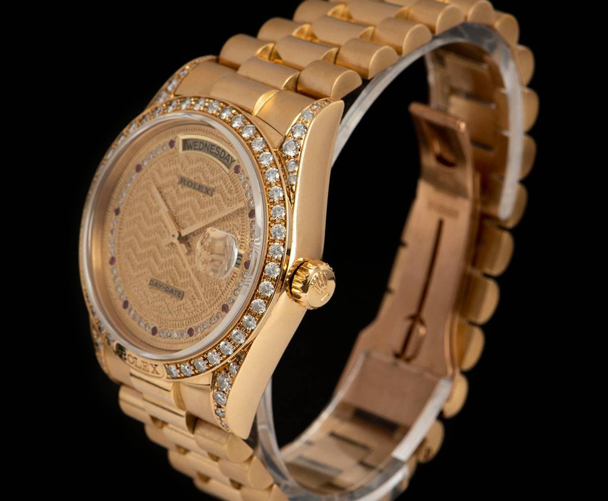 A Very Rare 18k Yellow Gold Oyster Perpetual Day-Date Gents Wristwatch, champagne decorated dial, a string of approximately 51 round brilliant diamonds and ruby hour markers, day aperture at 12 0'clock, date at 3 0'clock, a fixed 18k yellow gold