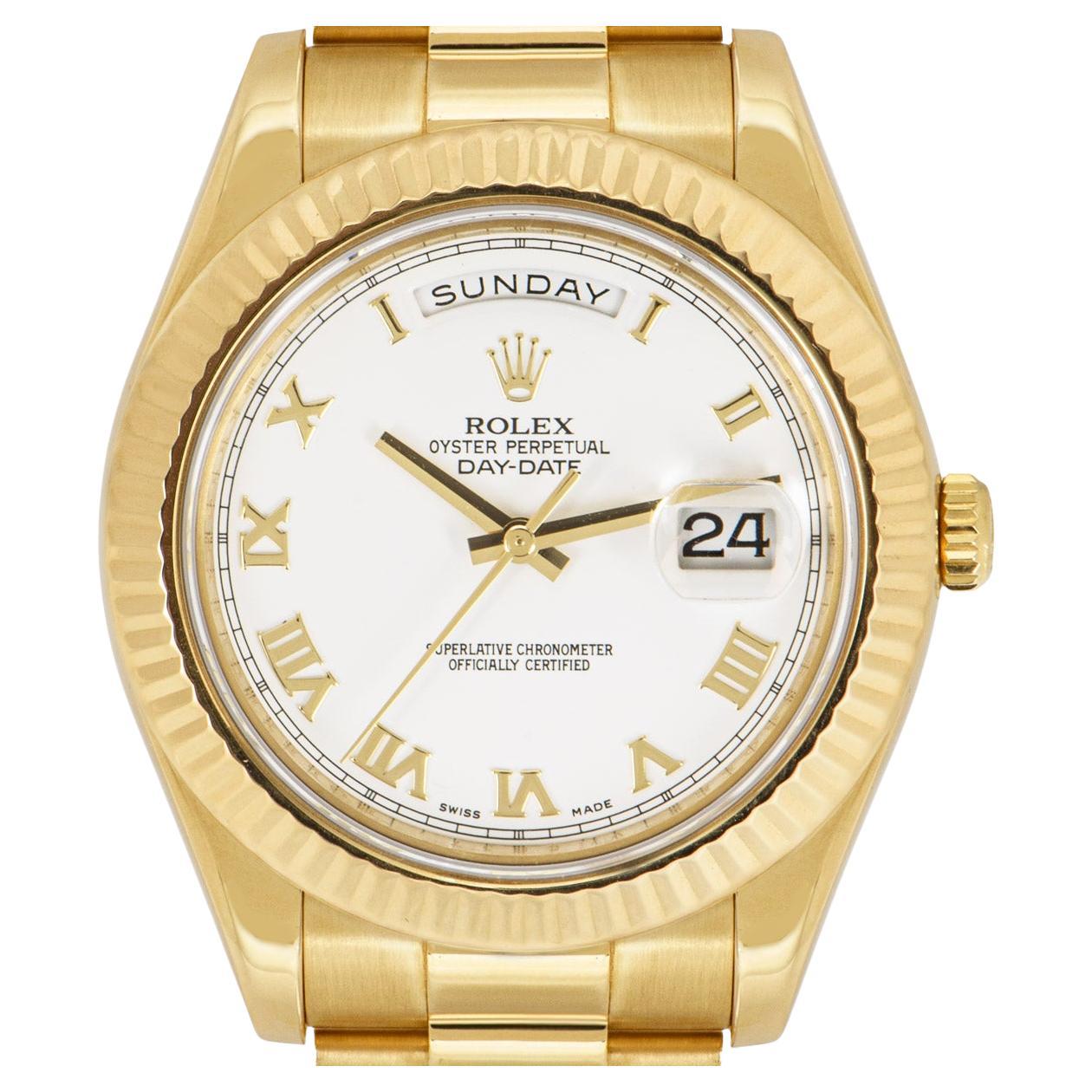 A yellow gold Day-Date II by Rolex. Featuring a white dial with roman applied numerals and a fluted yellow gold bezel. Fitted with a sapphire glass, a self-winding automatic movement and a yellow gold president bracelet set with a concealed folding