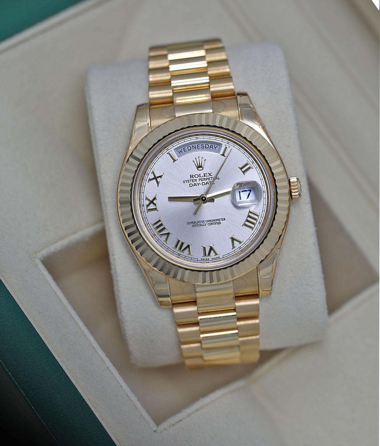 Rolex Day-Date II Yellow Gold Watch Silver Roman Dial Absolutely Never Worn/ Factory Stickers 218238 

18k yellow gold case with a 18k yellow gold Rolex President bracelet. Fixed - futed 18k yellow gold bezel. silver dial with yellow gold-tone hands