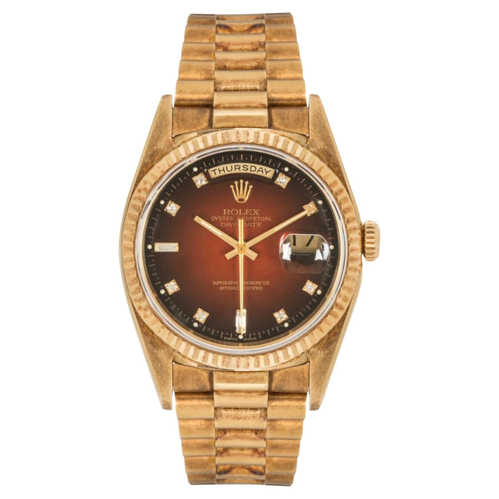 A stunning yellow gold Day-Date by Rolex. Featuring a striking maroon vignette dial set with 8 round brilliant cut diamonds and 2 baguette cut diamond hour markers, as well a day and date aperture.

Equipped with a yellow gold president bracelet and