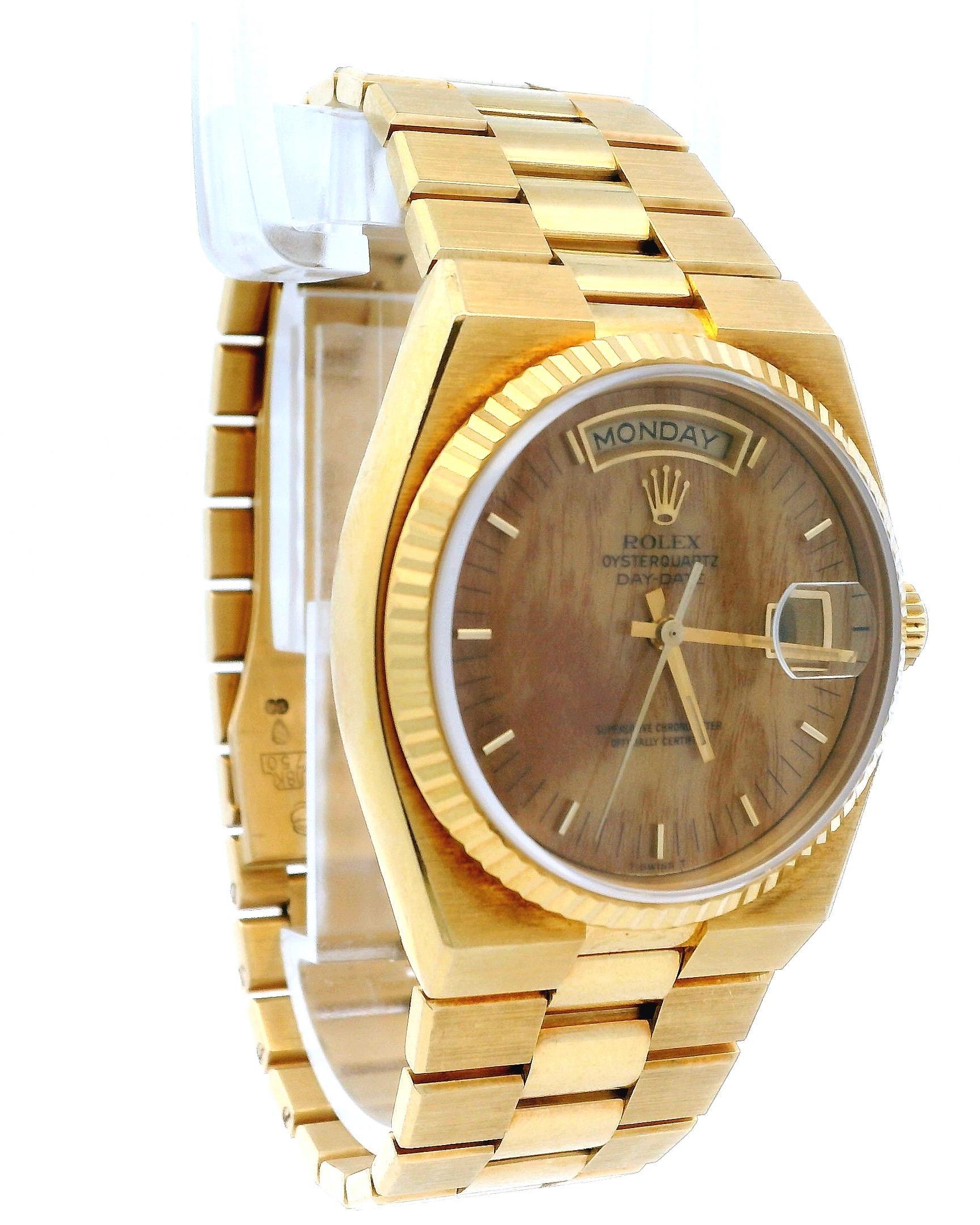 Rolex Oysterquartz President Day-Date Orologio da uomo 19018. Questo orologio presenta una cassa da 36 mm in oro giallo 18 carati e una lunetta scanalata in oro giallo 18 carati. Il quadrante è in legno di radica, completato da lancette luminose in