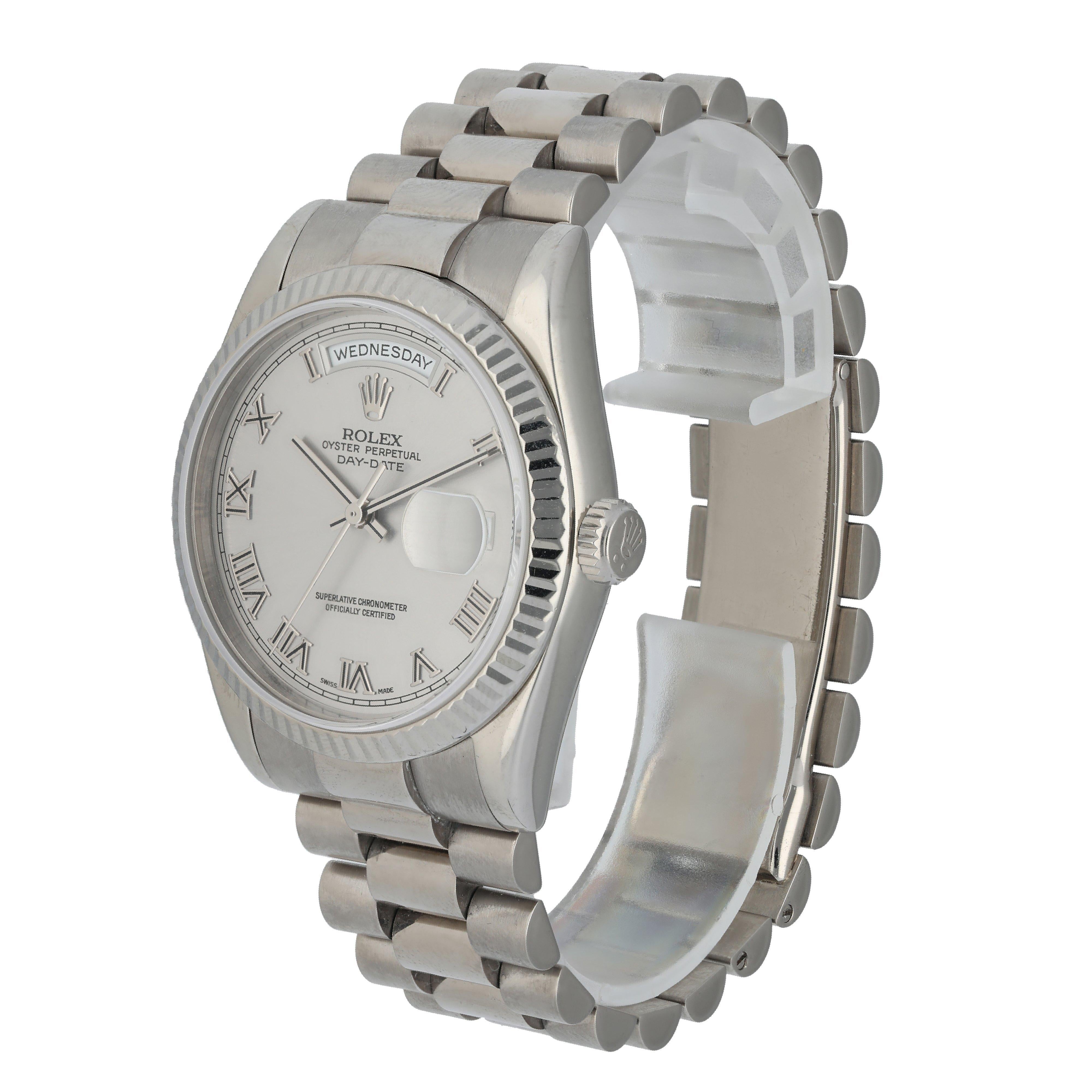 Rolex Day-Date President 118239 men's Watch.
36mm white gold case with fluted white gold bezel.
Silver dial with gold hands and Roman numeral hour markers.
Minute markers around the outer dial.
Date display at the 3 o'clock position and a day
