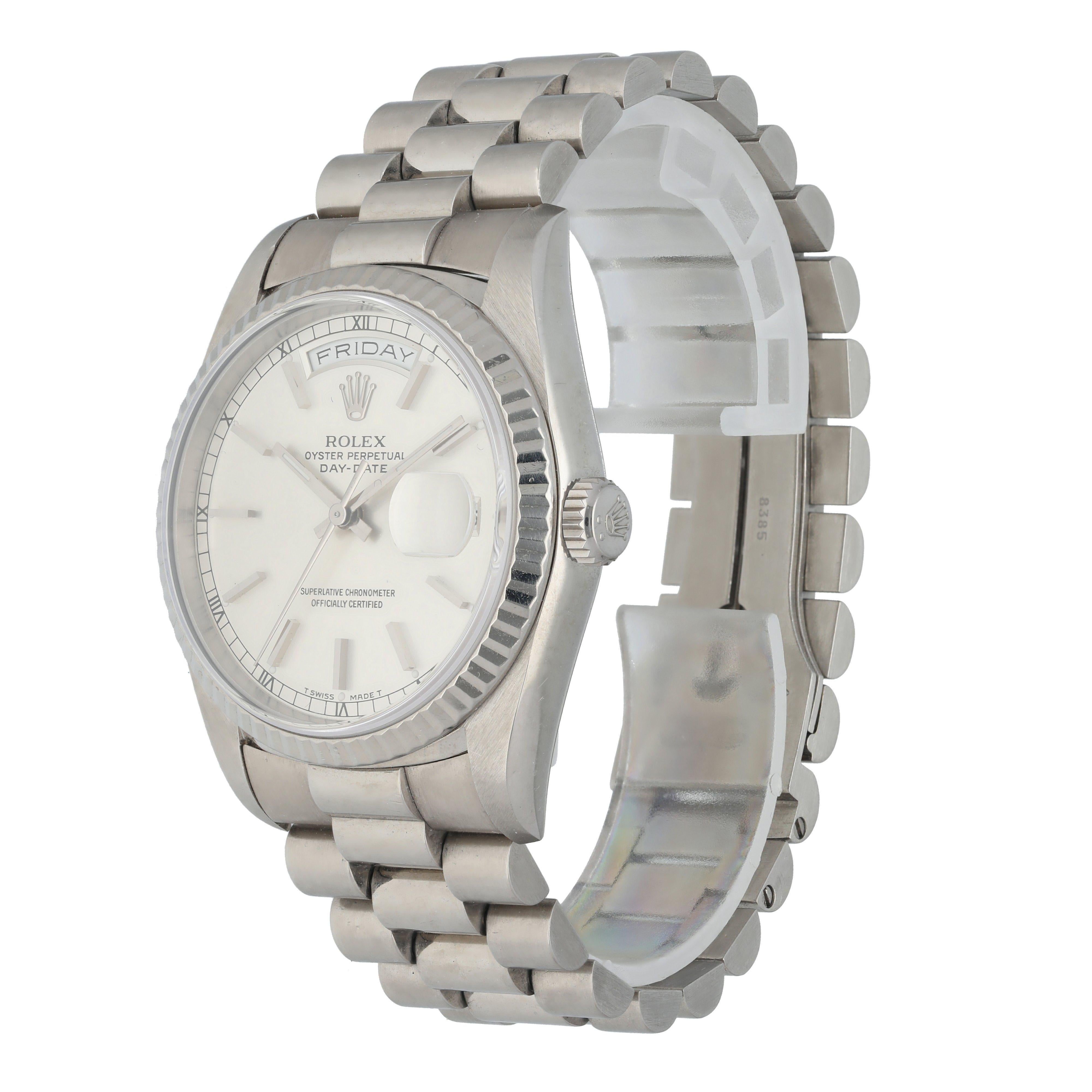 Rolex Day-Date 18239 Men's Watch.
36mm 18K White Gold case. 
White Gold fluted bezel. 
Grey dial with Roman numeral hour markers.
Minute markers on the outer dial. 
Date display at the 3 o'clock position. 
White Gold Bracelet with Fold Over Clasp.