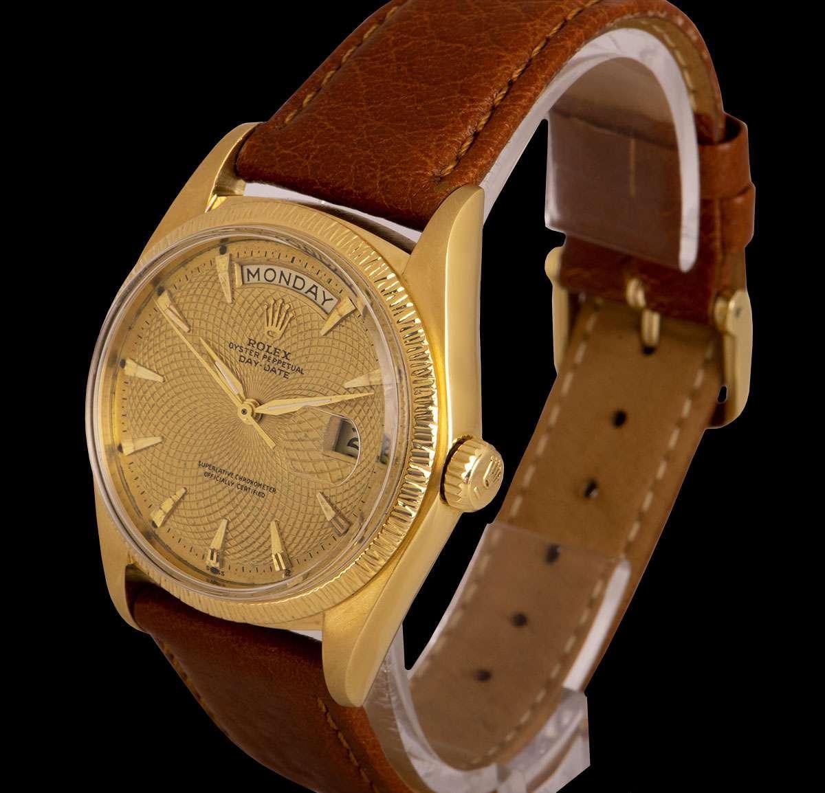 A 36 mm 18k Yellow Gold Oyster Perpetual Day-Date Vintage Gents Wristwatch, rare champagne guilloche geometric dial with applied hour markers, day at 12 0'clock, date at 3 0'clock, a fixed 18k yellow gold bark finish bezel, a brand new brown leather