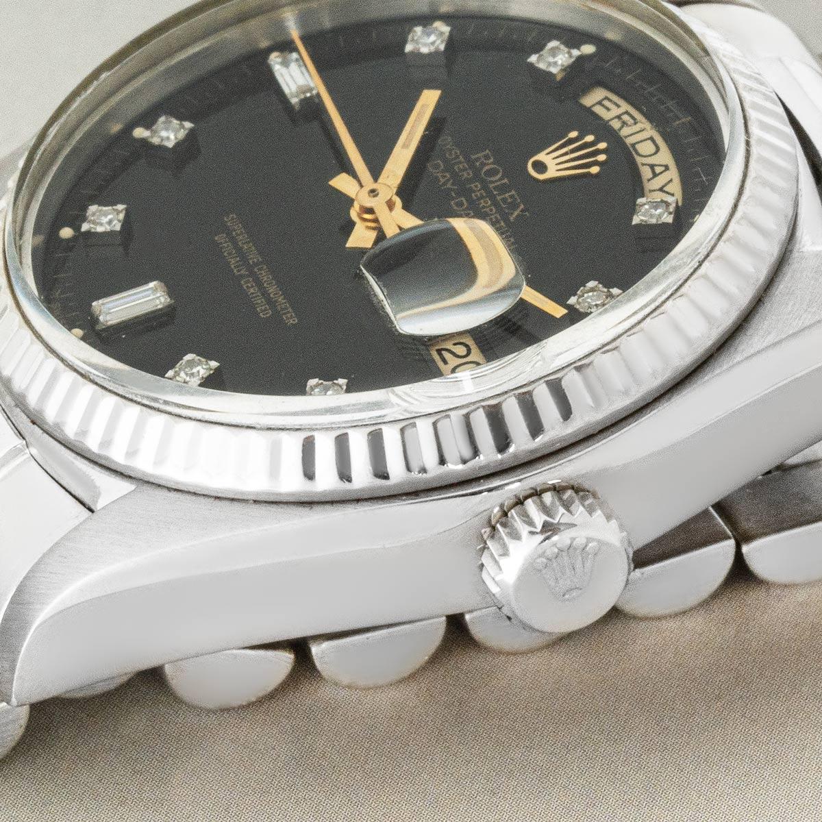 A 36mm vintage Day-Date in white gold by Rolex. Features a black dial set with 8 round brilliant cut diamonds and 2 baguette cut diamonds, complemented by a fixed white gold fluted bezel.

Fitted with plastic glass, a self-winding automatic
