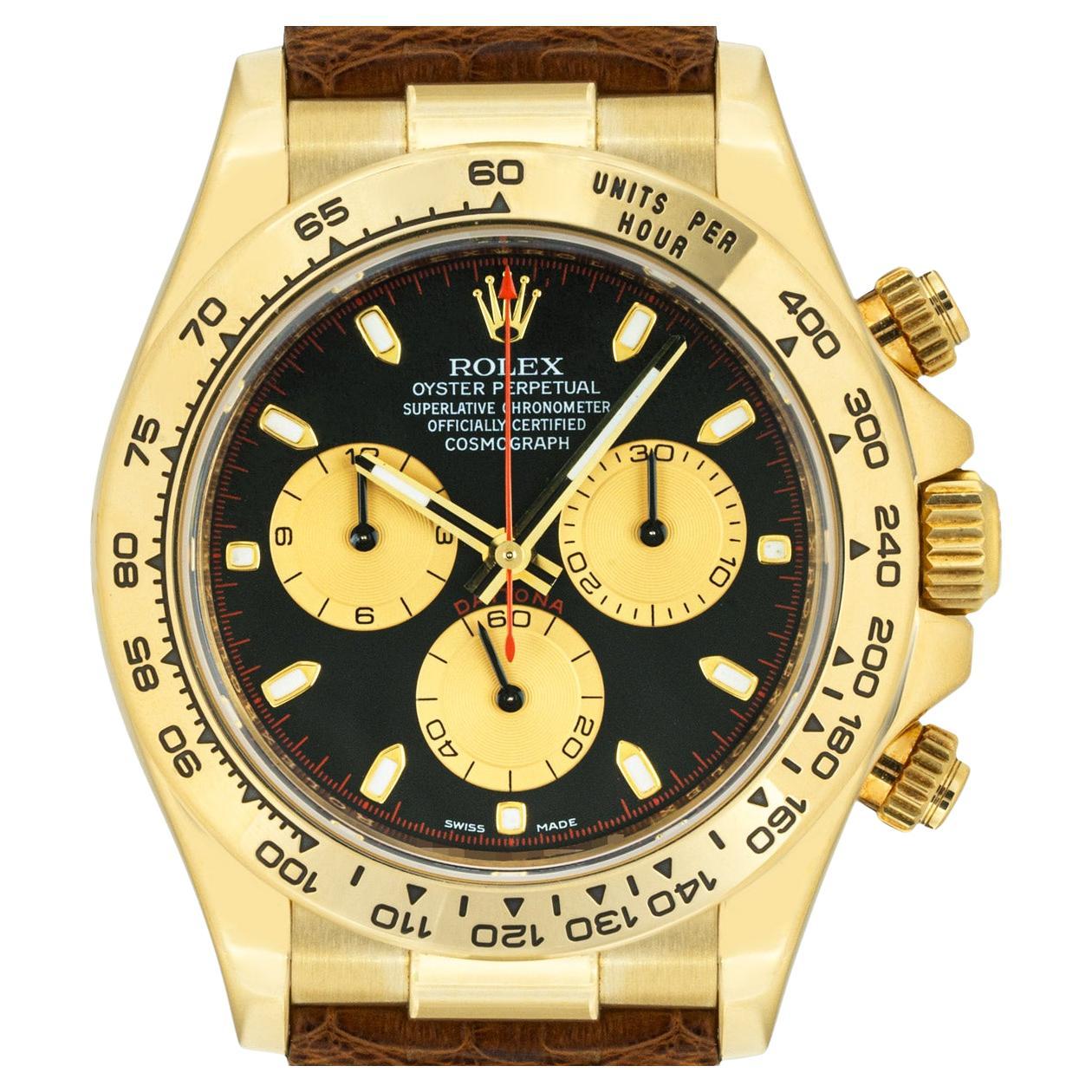 A mens yellow gold Cosmograph Daytona by Rolex. Featuring a black and champagne-colour dial with red detailing known as a Paul Newman dial and a yellow-gold bezel set with a tachymetric scale, three counters and pushers.

Fitted with a