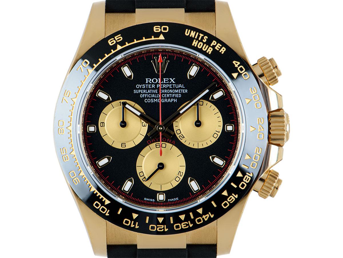 An unworn yellow gold Cosmograph Daytona by Rolex, featuring a black and champagne-colour dial which can be referred to as a Paul Newman dial due to the red detailing. Featuring a ceramic bezel with a moulded tachymetric scale, three counters and