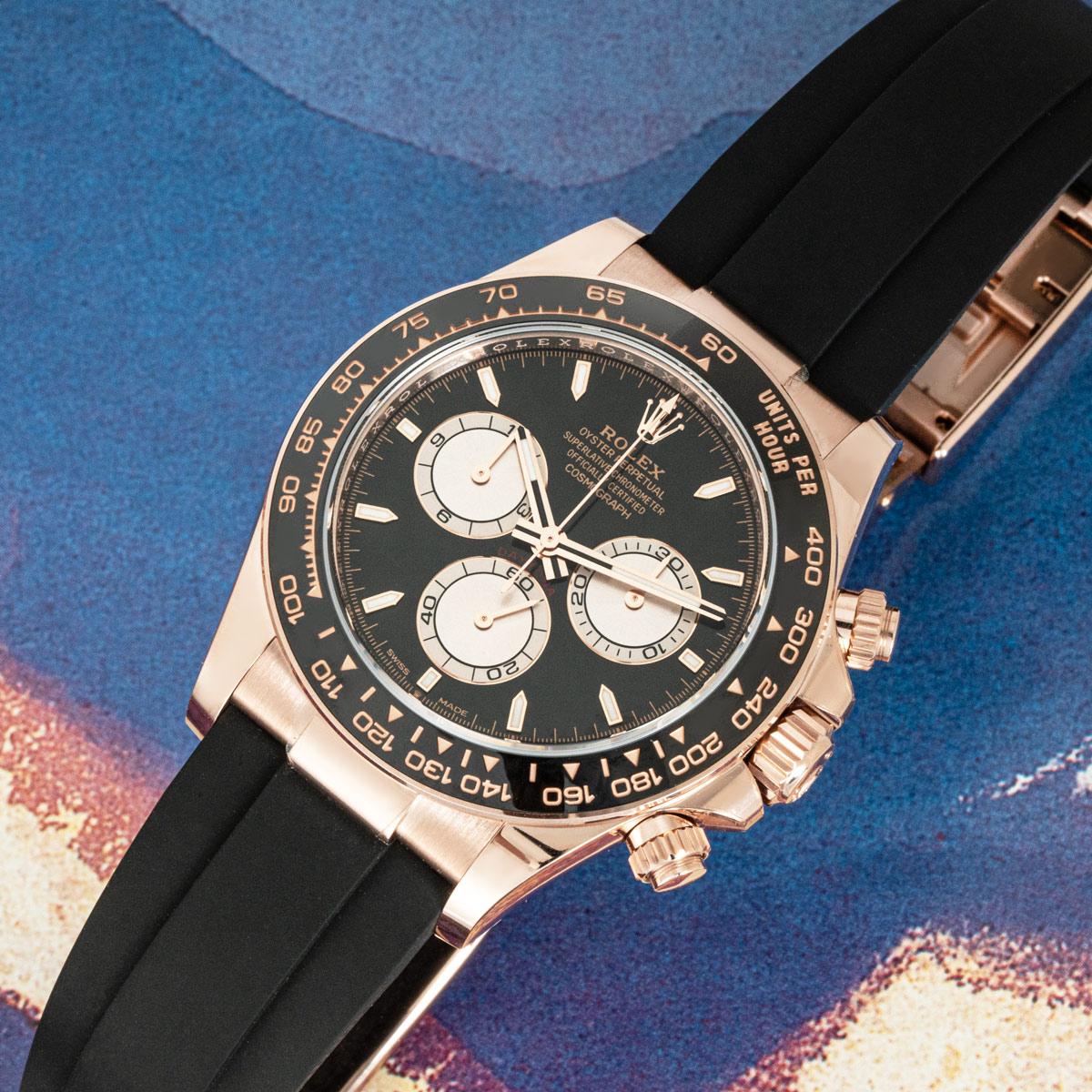 Un Oysterflex Daytona de oro rosa de Rolex sin estrenar. Con una esfera de color Negro Brillante y Sundust con pantalla cromaluminosa. También incorpora un bisel de cerámica negra con escala taquimétrica moldeada, tres contadores y pulsadores; el