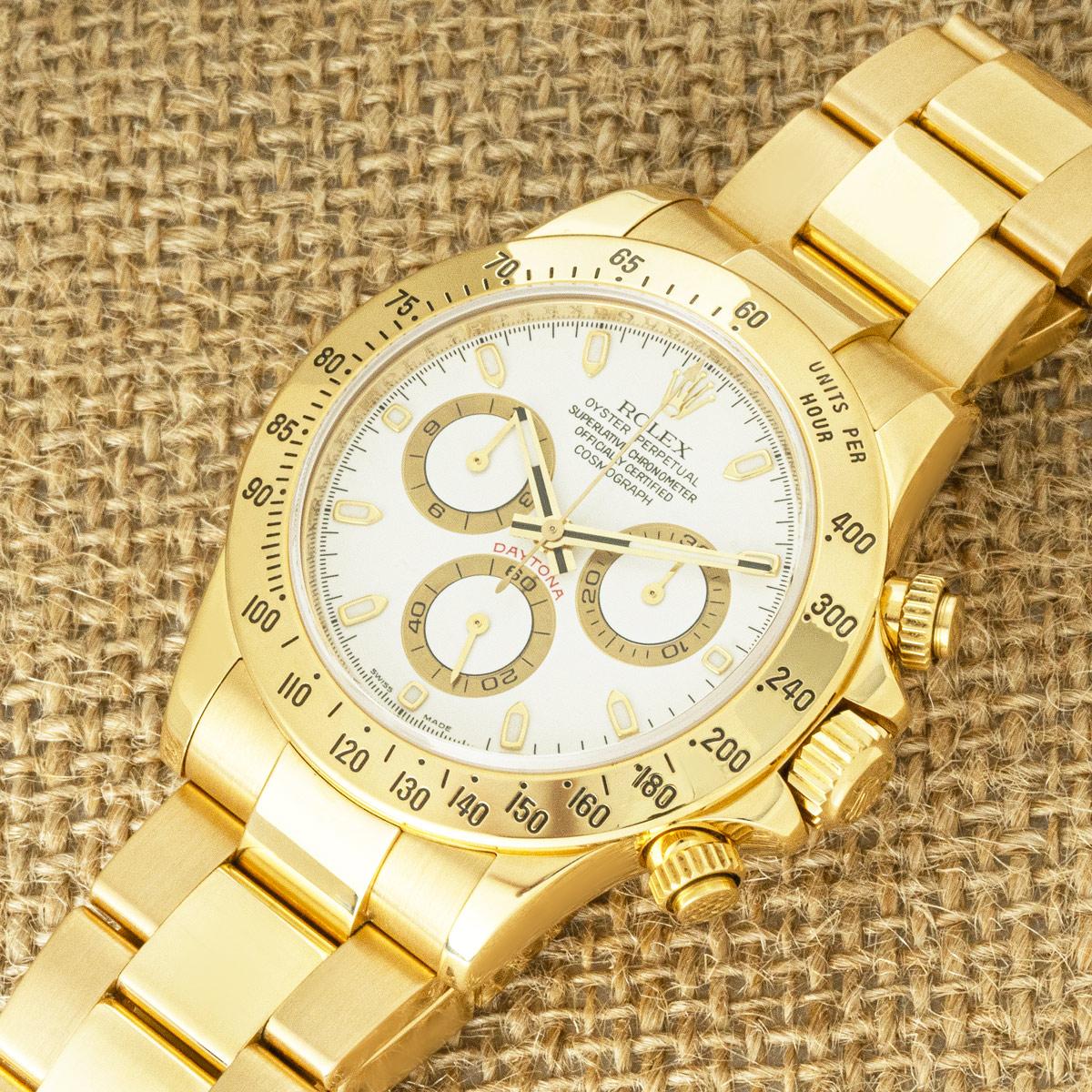 A Daytona in yellow gold by Rolex. Features a white dial with applied hour markers, a tachymetric scale, three counters and pushers; the Daytona was designed to be the ultimate timing tool for endurance racing drivers.

The Oyster bracelet is