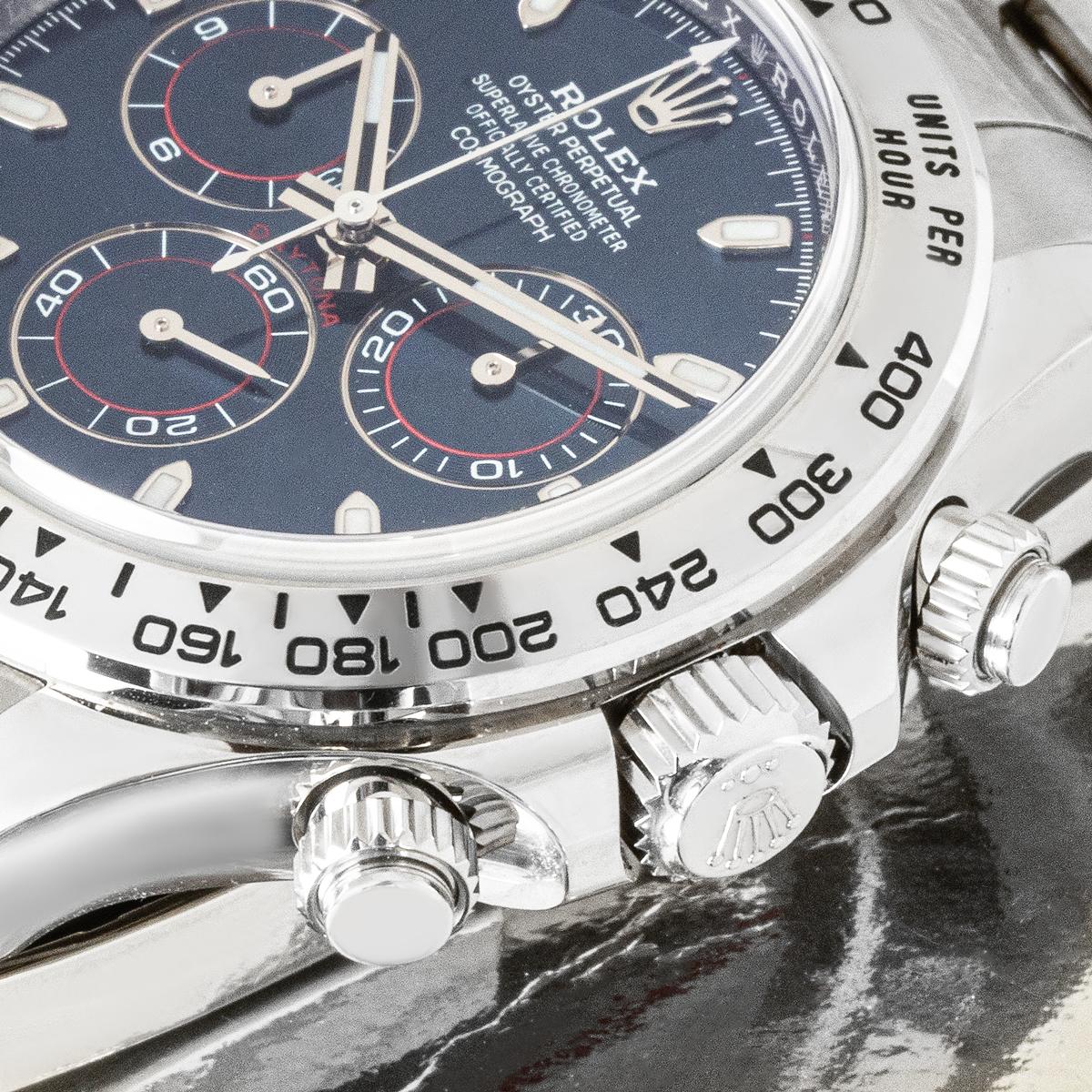 Eine Daytona aus Weißgold von Rolex mit blauem Zifferblatt und Chronographenzählern. Die Uhr verfügt außerdem über eine eingravierte tachymetrische Skala und drei Drücker, die als ultimatives Zeitmessinstrument für Langstreckenrennfahrer konzipiert