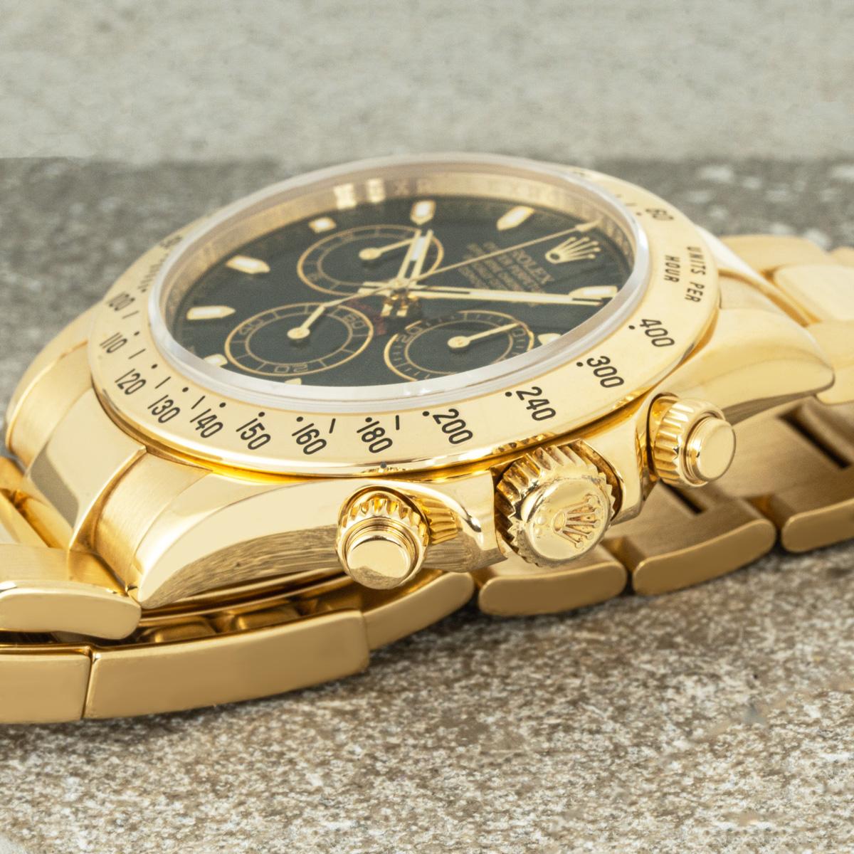 A Daytona in yellow gold by Rolex. Features a black dial with applied hour marker, a tachymetric scale, three counters and pushers; the Daytona was designed to be the ultimate timing tool for endurance racing drivers.

The Oyster bracelet is