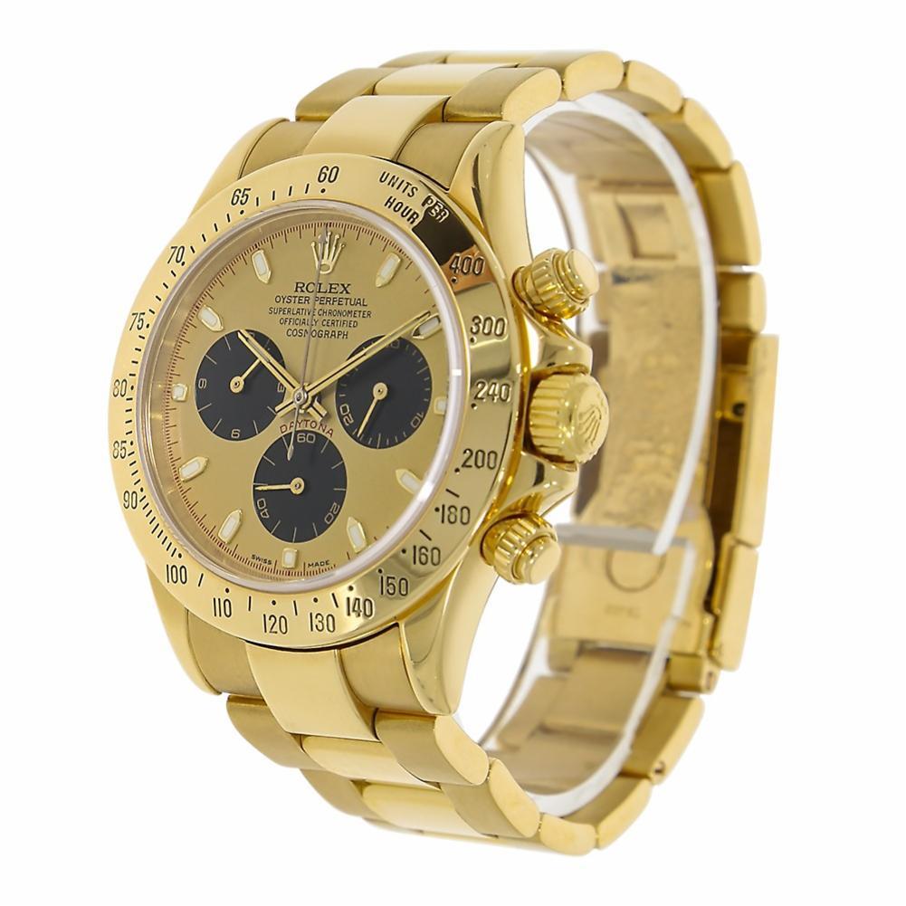 Rolex Daytona Reference #:116528. 18k yellow gold case with a 18k yellow gold oyster bracelet. Engraved bezel bezel. 40mm case, tachymeter engraved bezel, screw-down push buttons, champagne Paul Newman dial with black subdials, and Oysterlock
