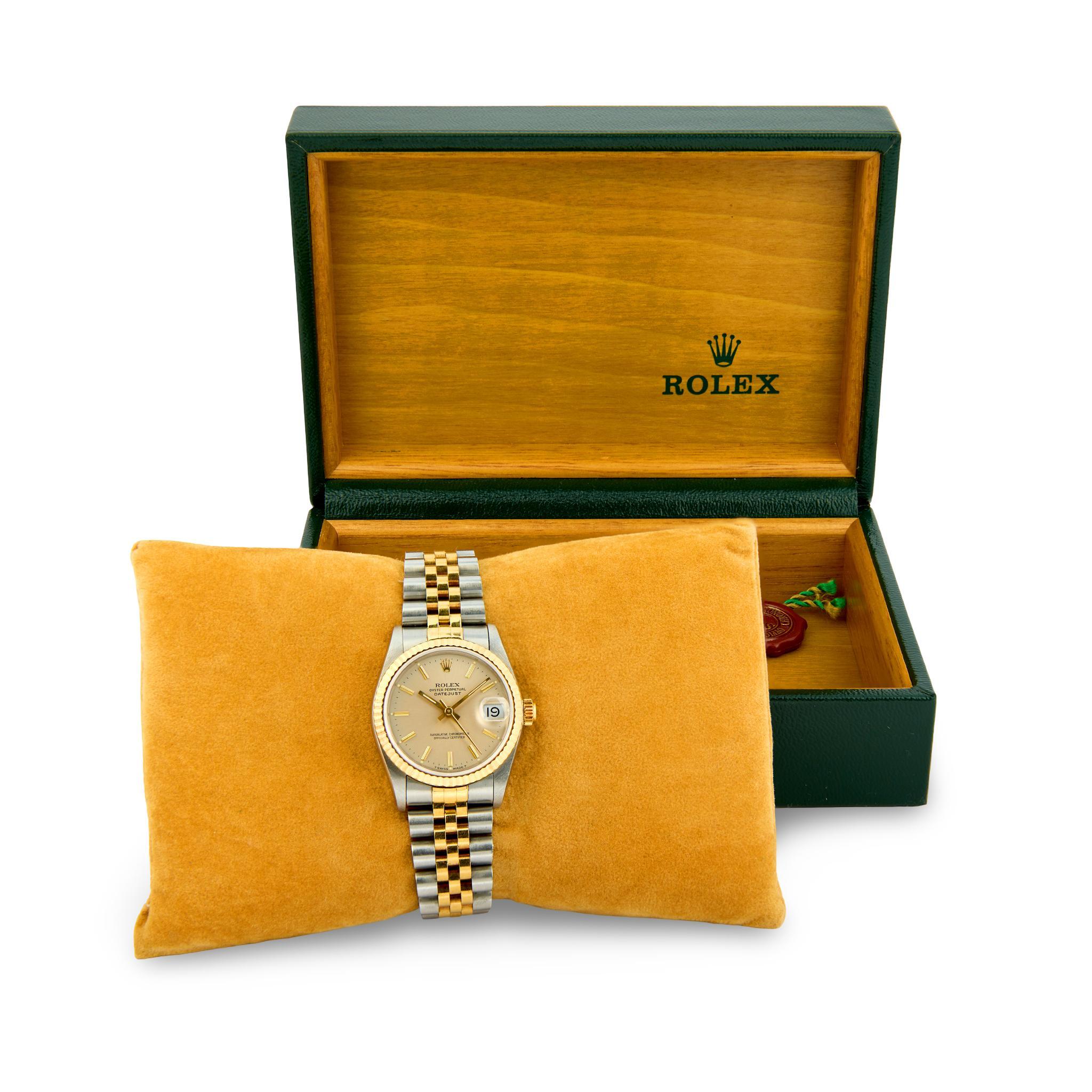 A gorgeous Rolex wristwatch! Crafted in vibrant 18k yellow gold and stainless steel, this Lady-Datejust watch was created in the mid 1980s! The circular face of the watch features twelve gold dashes and three gold hands. Additionally, the face is