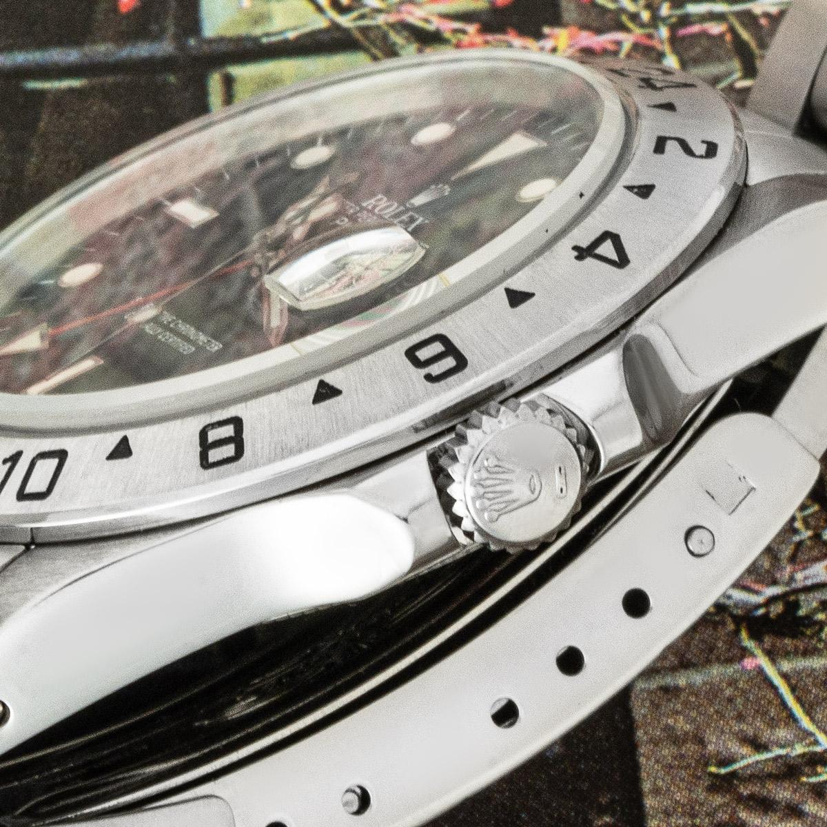 Eine 40 mm Explorer II von Rolex. Sie verfügt über ein schwarzes Zifferblatt mit Datumsanzeige, einen roten 24-Stunden-Zeiger und eine feste Lünette aus Edelstahl mit einer 24-Stunden-Anzeige. Die Uhr ist mit einem Saphirglas, einem Automatikwerk