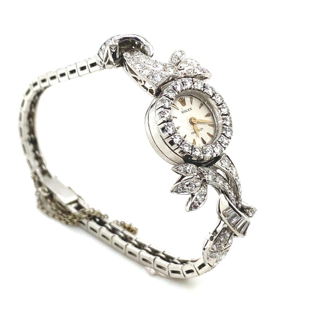 An exceptional and rare diamond set Art Deco style 18 karat white gold cocktail watch by Rolex for Kutchinsky.

With a manual wind movement, diamond set 18 karat white gold bezel featuring an off white dial and golden V shaped hour markers. 

The