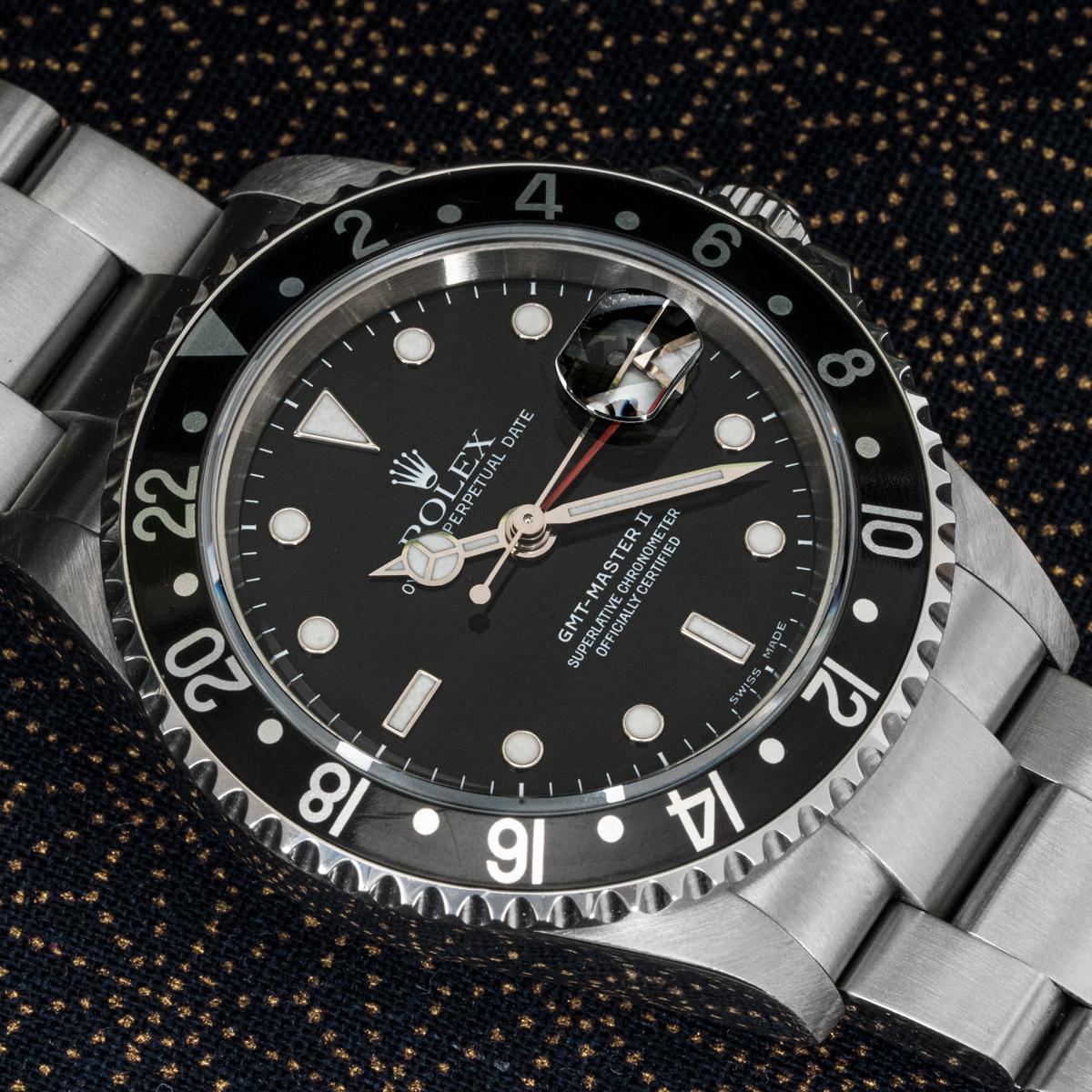 Une GMT-Master II en acier inoxydable de Rolex. Le cadran noir est doté d'un guichet de date et d'une aiguille rouge pour le second fuseau horaire. La lunette rotative bidirectionnelle est également dotée d'un affichage 24 heures.

La montre est