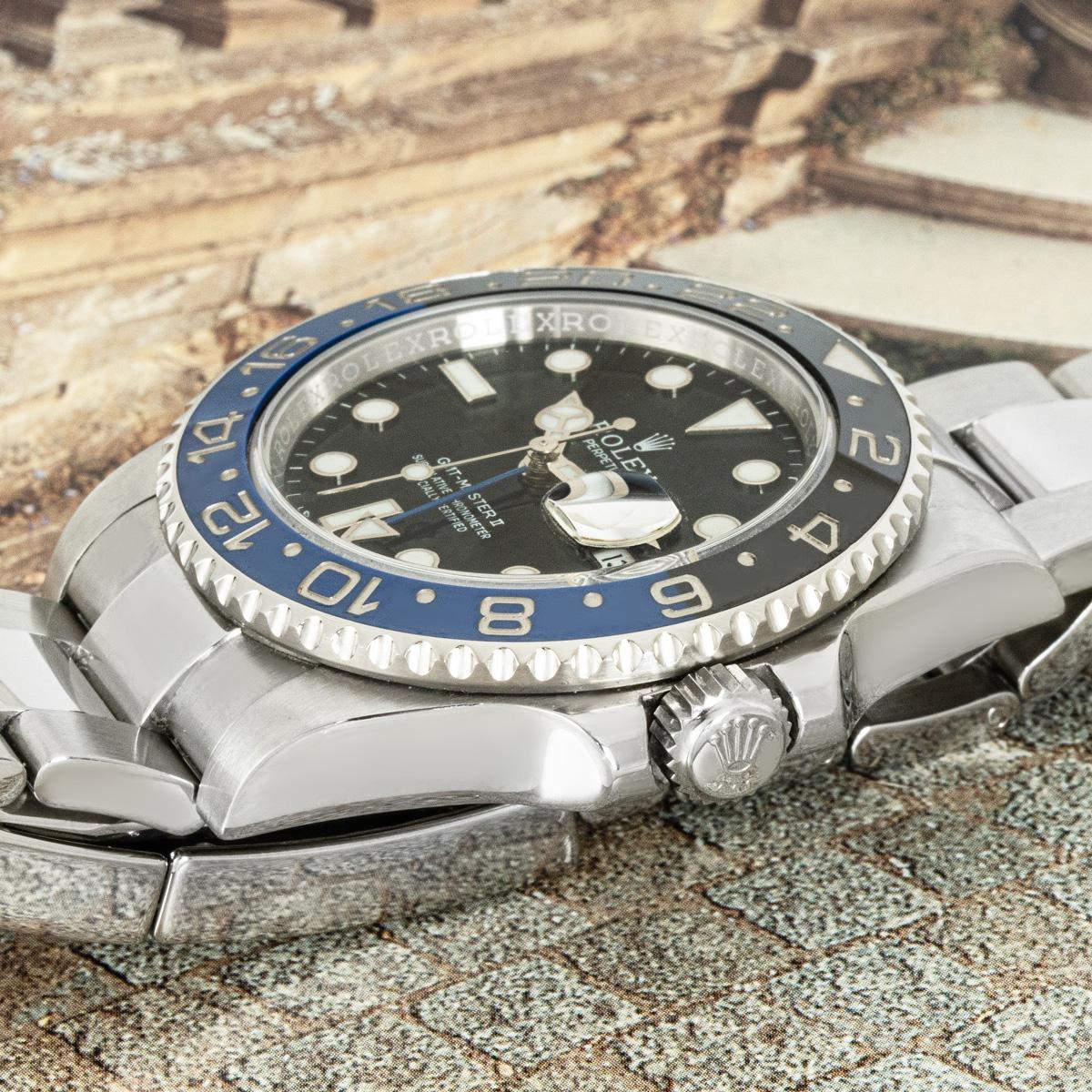 A stainless steel GMT-Master II Batman by Rolex. Features a black dial with the date display and blue time zone hand. The ceramic black and blue bidirectional rotatable bezel features a 24-hour display. The Oyster bracelet comes equipped with a