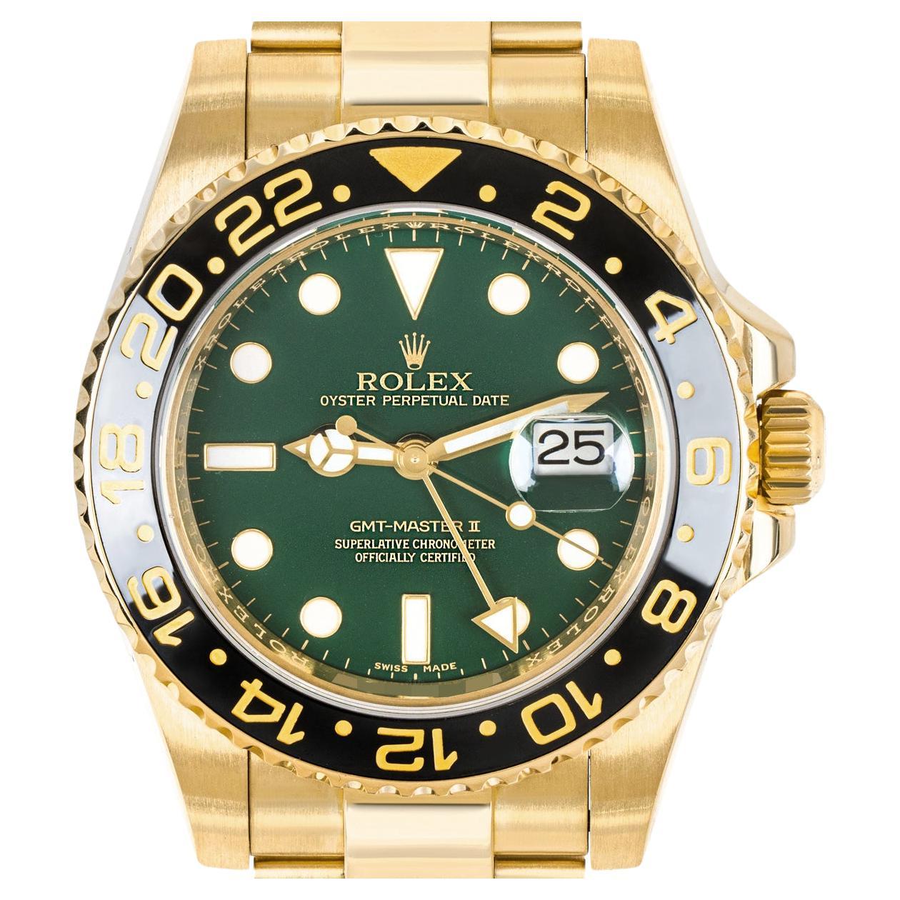 A men' s GMT-Master wristwatch, crafted from 18k yellow gold by Rolex. Featuring a distinctive green dial with gold applied hour markers and a date aperture at 3 o'clock. Complementing the dial is a yellow gold bi-directional rotatable bezel with a
