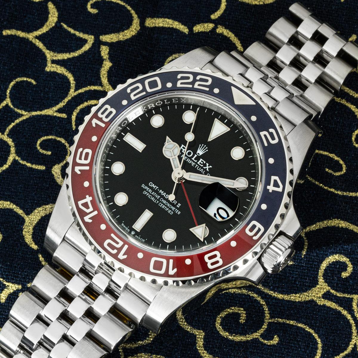An Oystersteel GMT-Master II Pepsi from Rolex. Features a black dial with the date and red time zone hand. The blue and red bidirectional rotatable ceramic bezel also features a 24 hour display.

The Jubilee bracelet comes with the folding