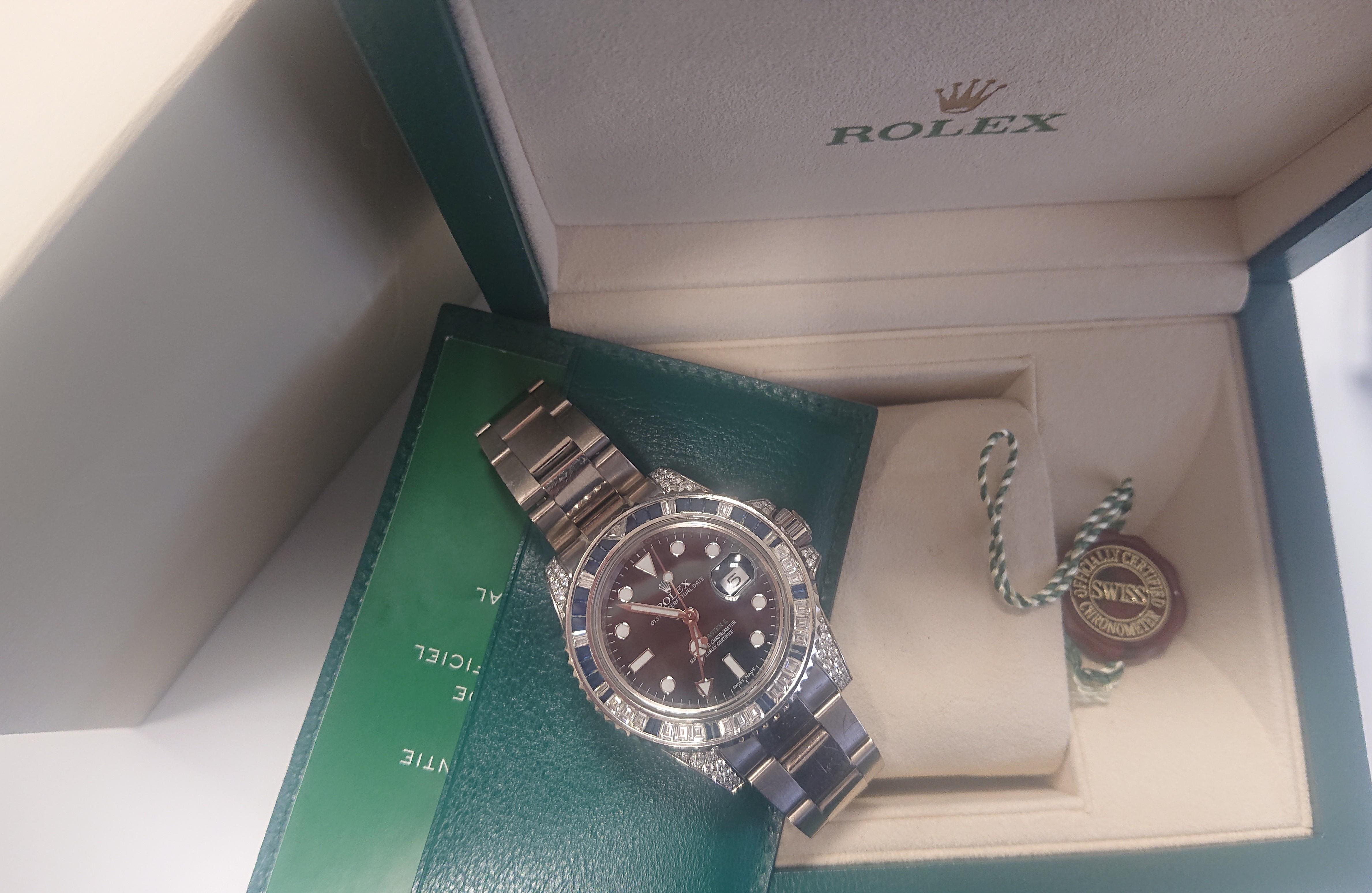 Rolex GMT Master II White Gold Sapphire and Diamond Ref 116759 Wristwatch. Rolex Oyster Perpetual GMT-Master II Watch. 40mm diameter. 18ct white gold case set with diamonds and sapphires. Black dial with date and numbered 3MR66266. 18ct white gold