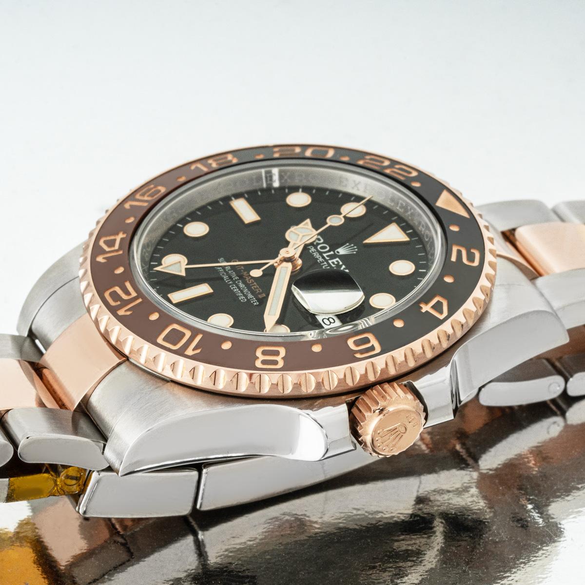 Une GMT-Master II Root Beer en Oystersteel et or rose de Rolex, présentant un cadran noir avec la date et l'aiguille du second fuseau horaire. La lunette tournante bidirectionnelle en céramique bicolore noire et brune affiche 24 heures.

Le bracelet