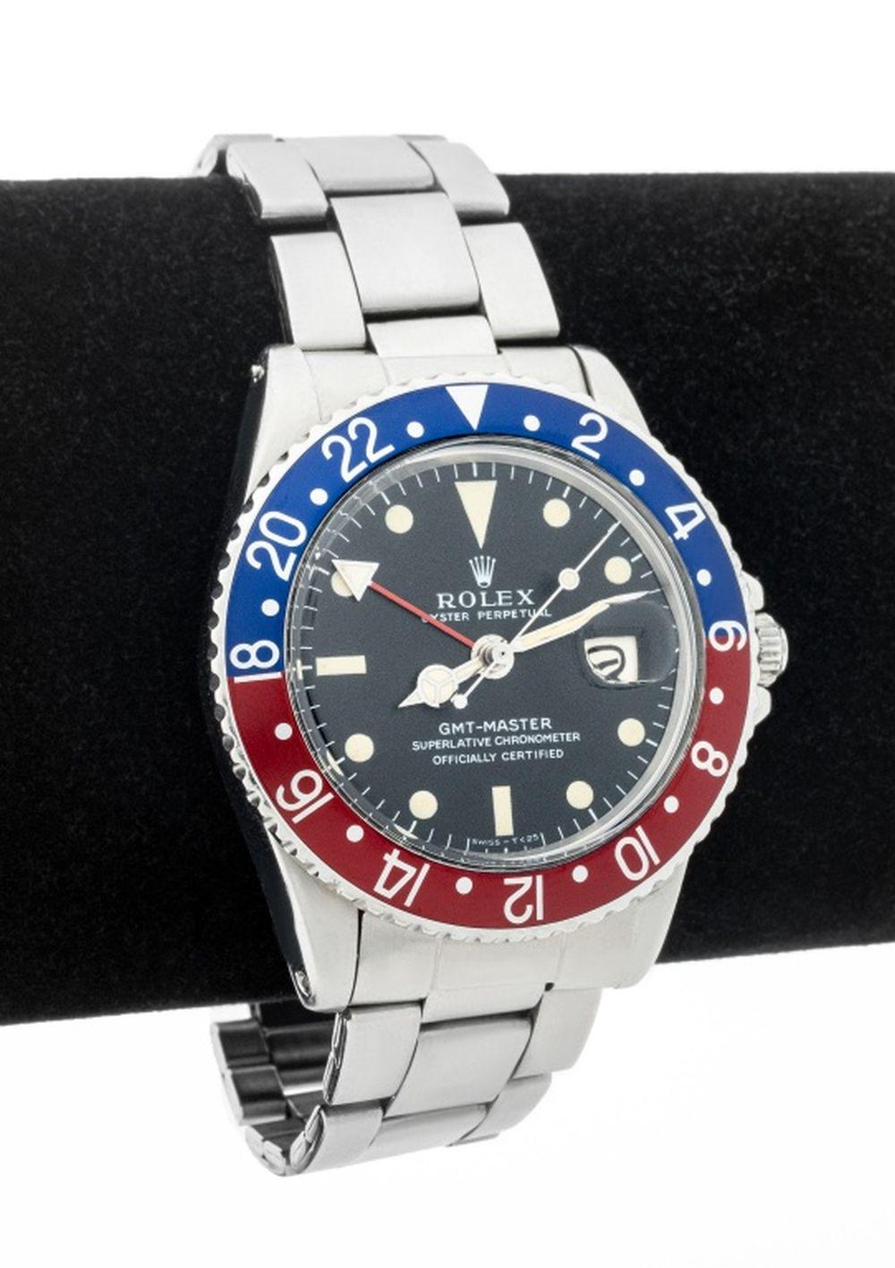 Rolex GMT Master in acciaio inossidabile con lunetta blu-rossa, referenza no. 1675 con quadrante nero, indici luminosi, datario a ore 3, alimentato da movimento automatico a carica automatica, calibro 1570, indossato al polso con bracciale oyster in