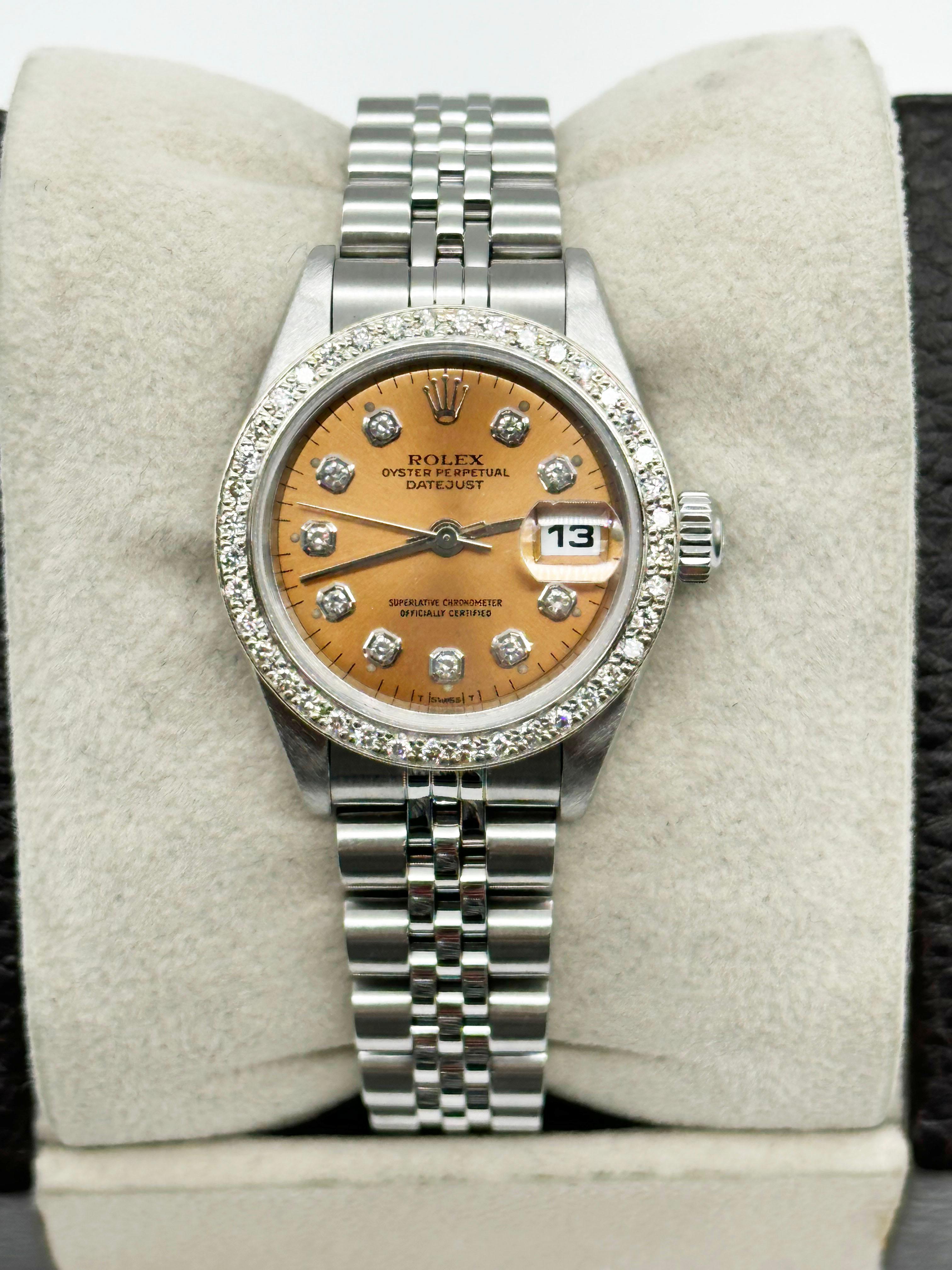 Style Number: 79160
Serial: P951***
Year: 2000
Model: Rolex Ladies Date
Case Material: Stainless Steel
Band: Stainless Steel
Bezel: Custom Diamond Bezel
Dial: Custom Bronze Diamond Dial
Face: Sapphire Crystal
Case Size: 26mm
Includes: 
-Elegant