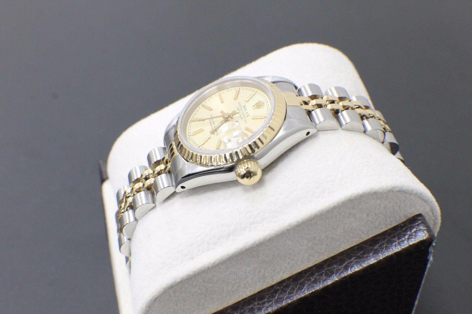 Style Number: 69173

Serial: 9227***

Model: Datejust

Case: Stainless Steel

Band: 18K Yellow Gold & Stainless Steel

Bezel: 18K Yellow Gold

Dial: Champagne Tapestry

Face: Sapphire Crystal

Case Size: 26mm

Includes: 

-Rolex Box & Papers

-6