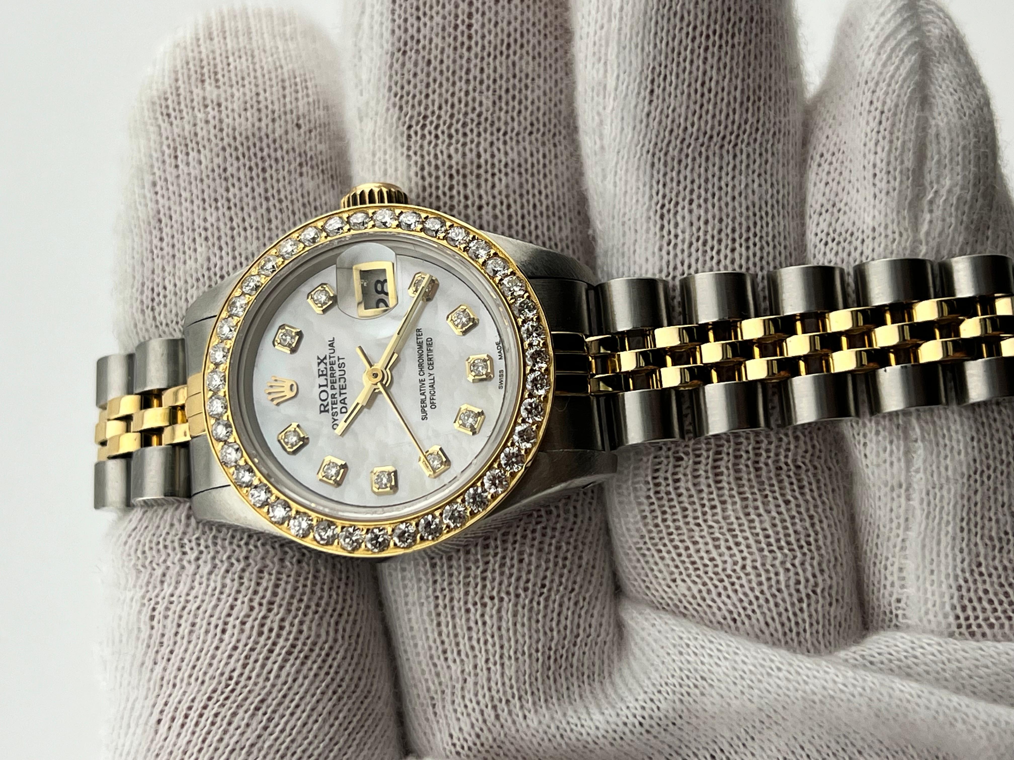 Style Number: 69173
Serial: R512***
Year: 1988
Model: Rolex Ladies Datejust 
Case Material: Stainless Steel 
Band: 18K Yellow Gold & Stainless Steel 
Bezel: Custom Diamond Bezel 
Dial: Custom MOP Diamond Dial 
Face: Sapphire Crystal 
Case Size: 26mm