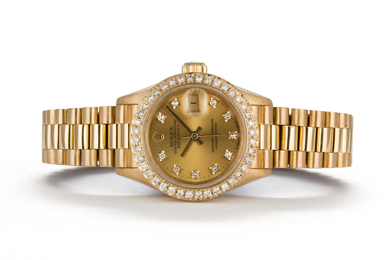 We are pleased to offer this 1991 Rolex 18k Yellow Gold & Diamond Ladies Datejust President 69178. This classic 26mm ladies watch features a solid 18k Yellow gold design with high quality custom diamond bezel and diamond dial. It will fit up to a