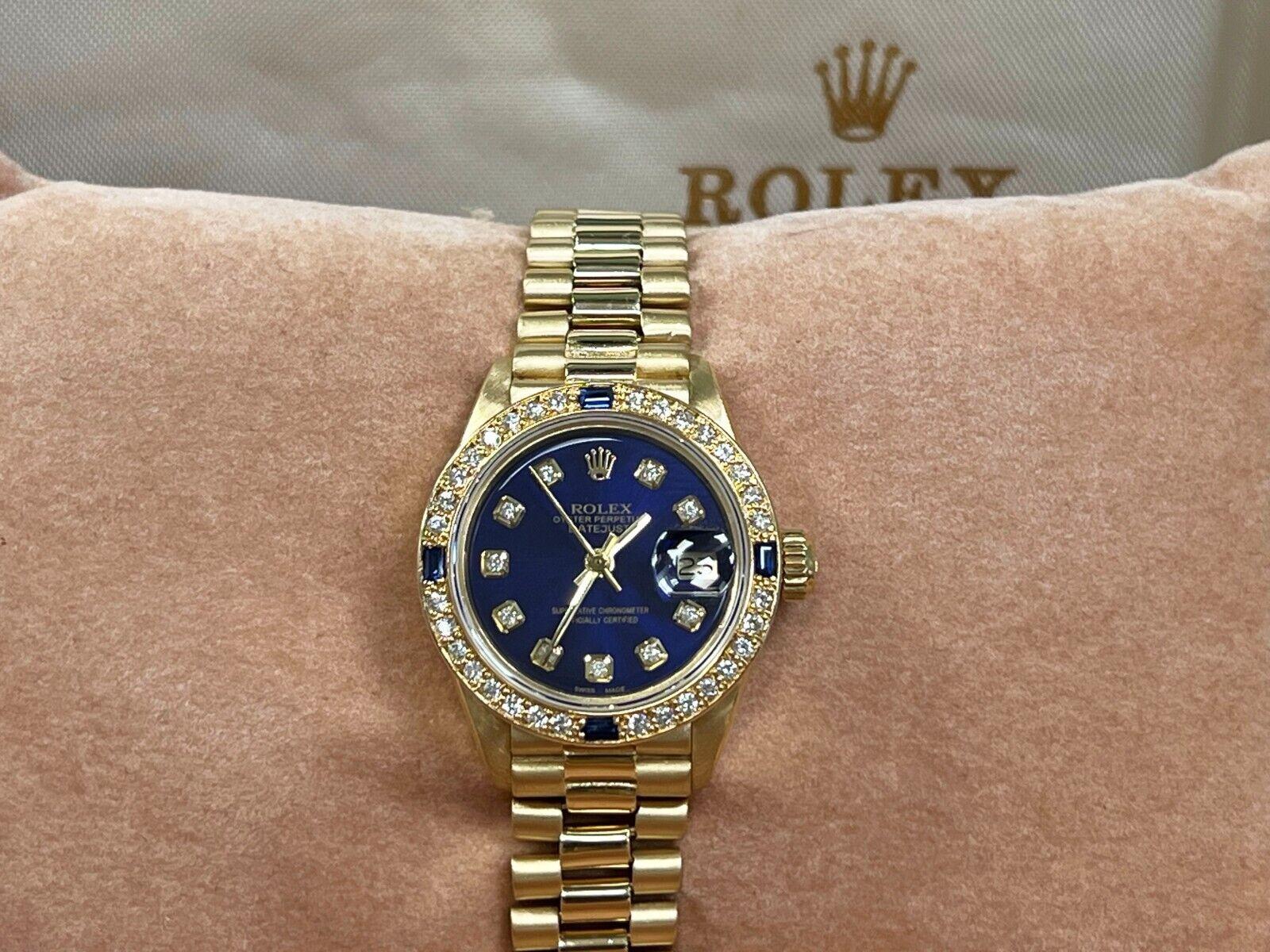Style Number: 6917

Serial: 7275***

Year: 1982

Model: Rolex Ladies President Datejust 

Case Material: 18K Yellow Gold 

Band: 18K Yellow Gold 

Bezel: Custom Diamond and Blue Sapphire Bezel 

Dial: Custom Blue Diamond Dial 

Face: Sapphire