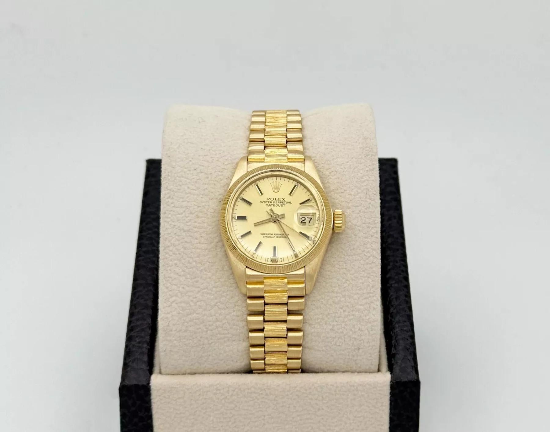 Style Number: 6927

Serial: 657****

Year: 1970

Model: Rolex Ladies President Datejust

Case Material: 18k Yellow Gold

Band: 18k Yellow Gold with Bark Finish

Bezel: 18k Yellow Gold with Bark Finish

Dial: Champagne

Face: Acrylic

Case Size:
