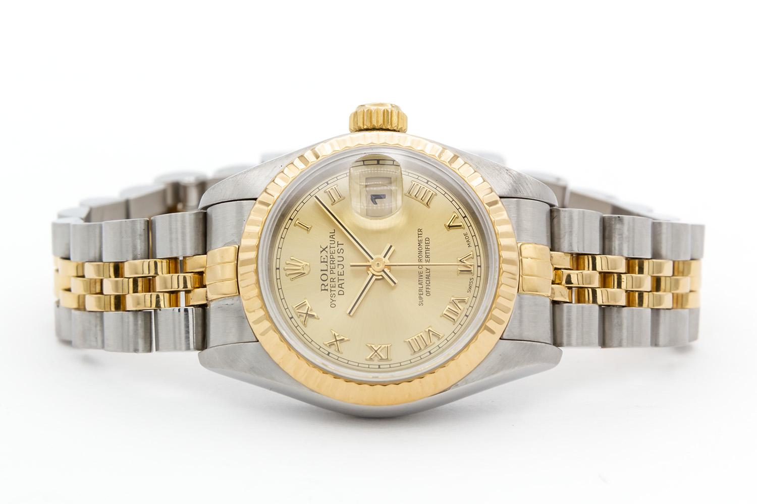 We are pleased to offer this 1993 Rolex Ladies Two Tone Datejust 69173. This is a classic ladies watch, timeless in its design. It features a 26mm stainless steel case, 18k yellow gold fluted bezel, champagne roman dial and two tone stainless steel