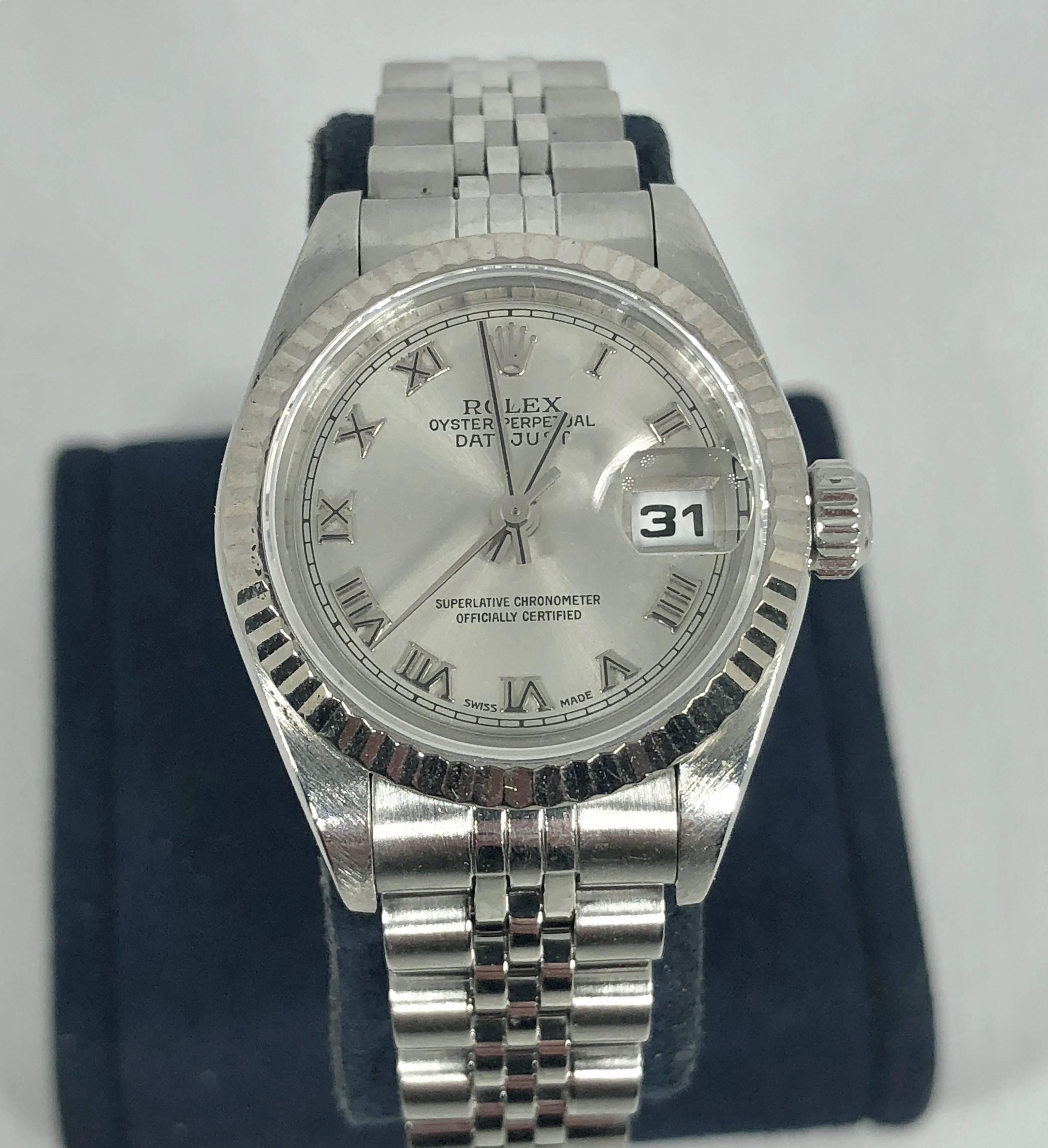 Rolex women's stainless steel and 18 karat Oyster perpetual Datejust wristwatch. Style #79174 serial # A989160. Circa 1999. Stainless steel and 18 karat white gold fluted bezel, 26 MM. Grey dial with roman numerals. Automatic movement with scratch