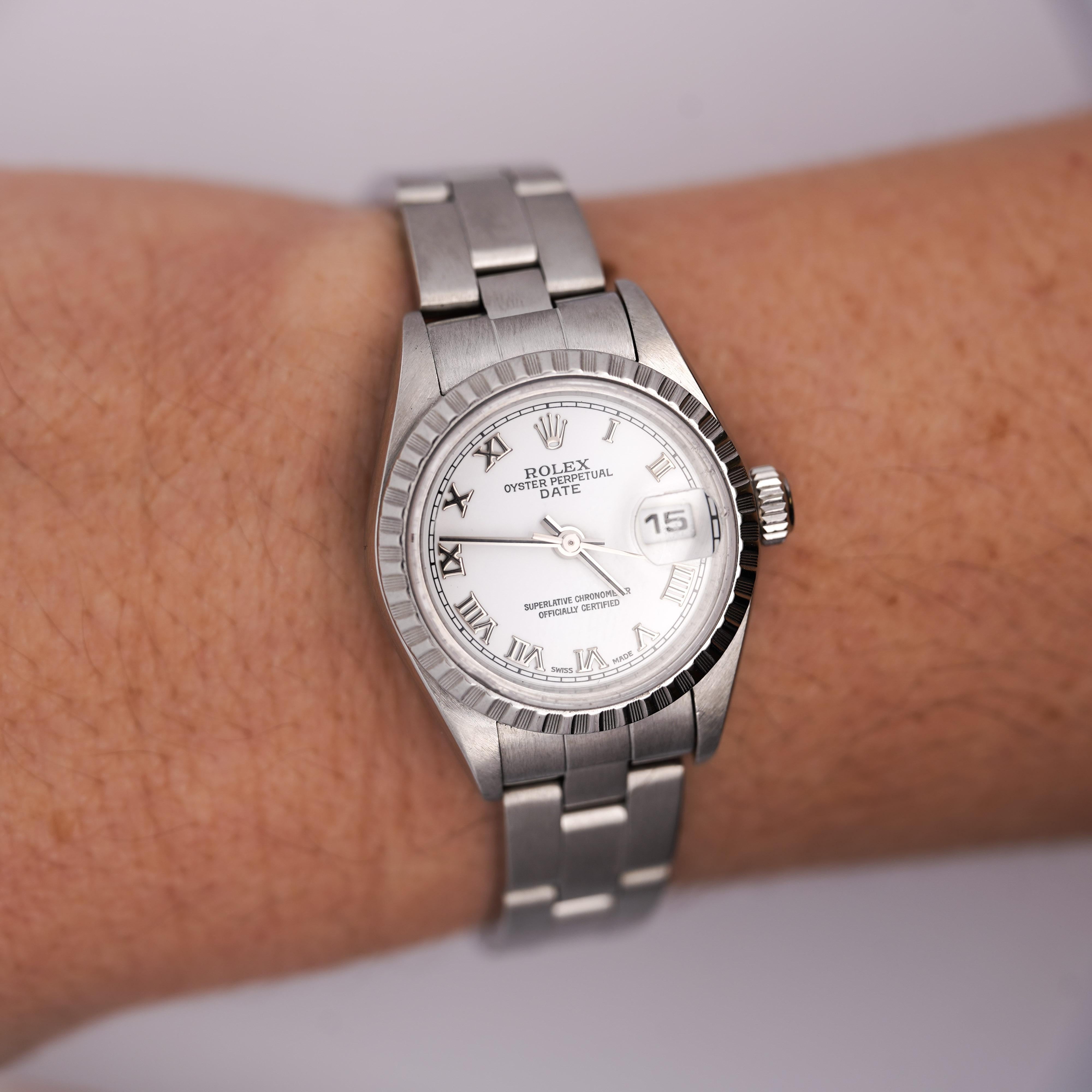 A vintage 2001 Rolex Lady-Date 79240, featuring a refined 24mm white face Roman numeral dial and a stainless steel Oyster bracelet and fluted bezel.

Complete with the original red Rolex box and papers.

Details:
Item Type: Luxury Wristwatch
Brand: