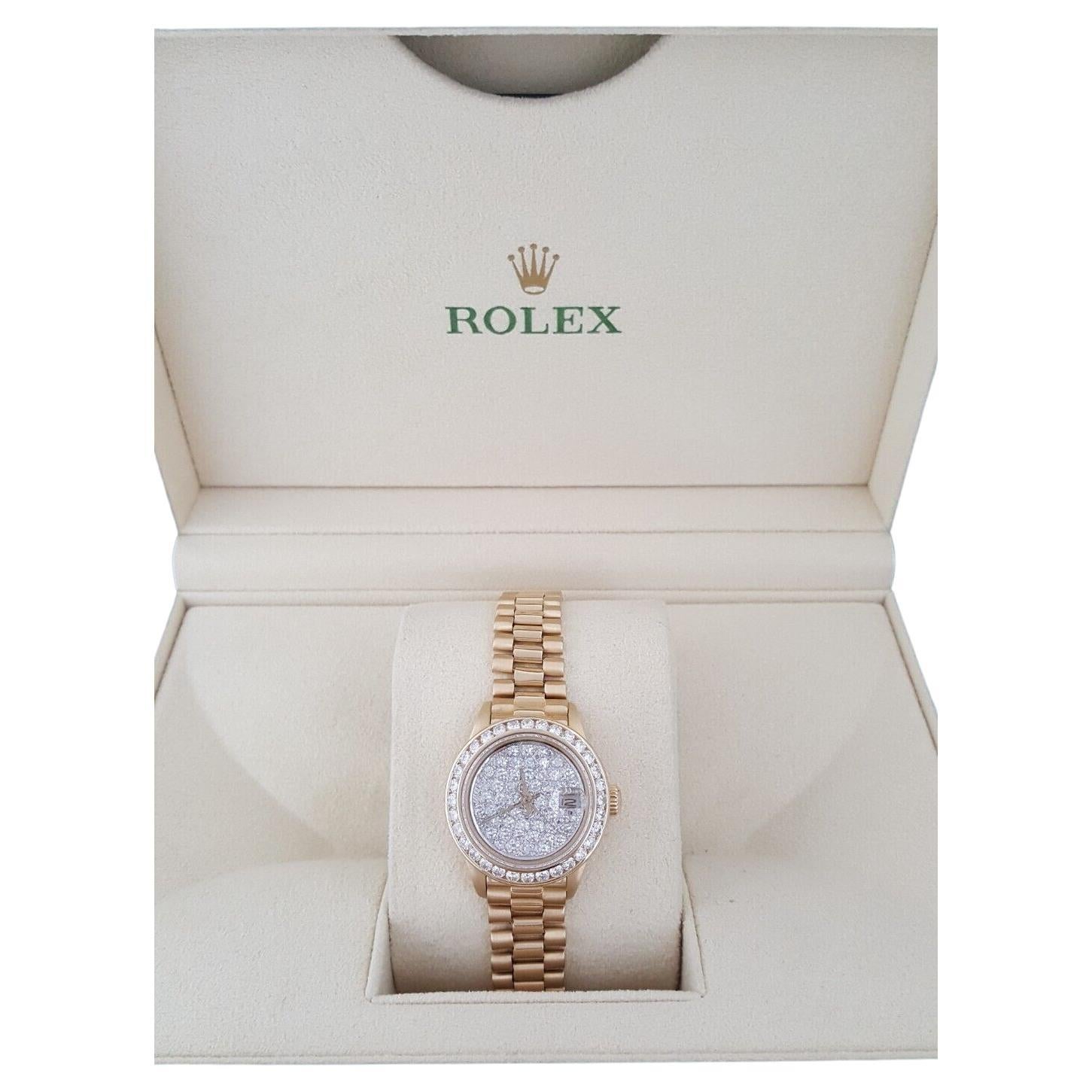 Authentique Rolex Lady Date-Just President 69178 Or jaune 18K 26 mm Factory Diamond Dial & Bezel.

La montre est dotée d'une couronne vissée, d'une lunette en or jaune 18K et diamants Factory, d'un verre saphir cyclope, d'un cadran champagne avec