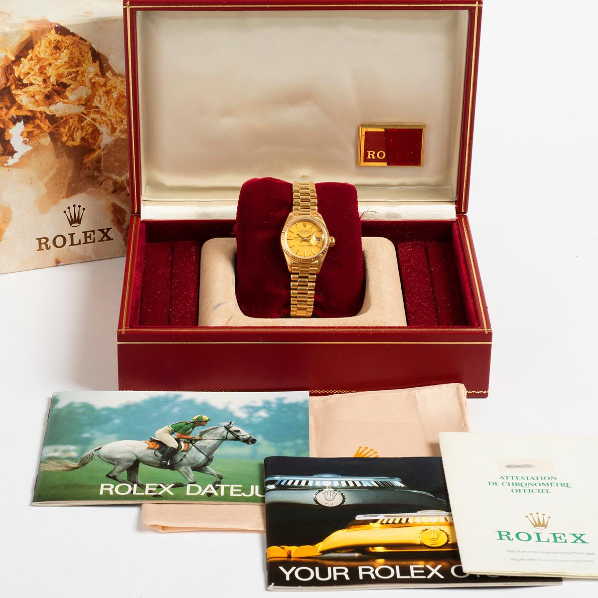 Our iconic vintage Rolex Lady Datejust, reference 69178 features an 18k yellow gold 26mm case and 18k yellow gold president bracelet and original champagne dial. A full set, comprising: inner and outer tapestry box with 69178 and gold tone stickers,