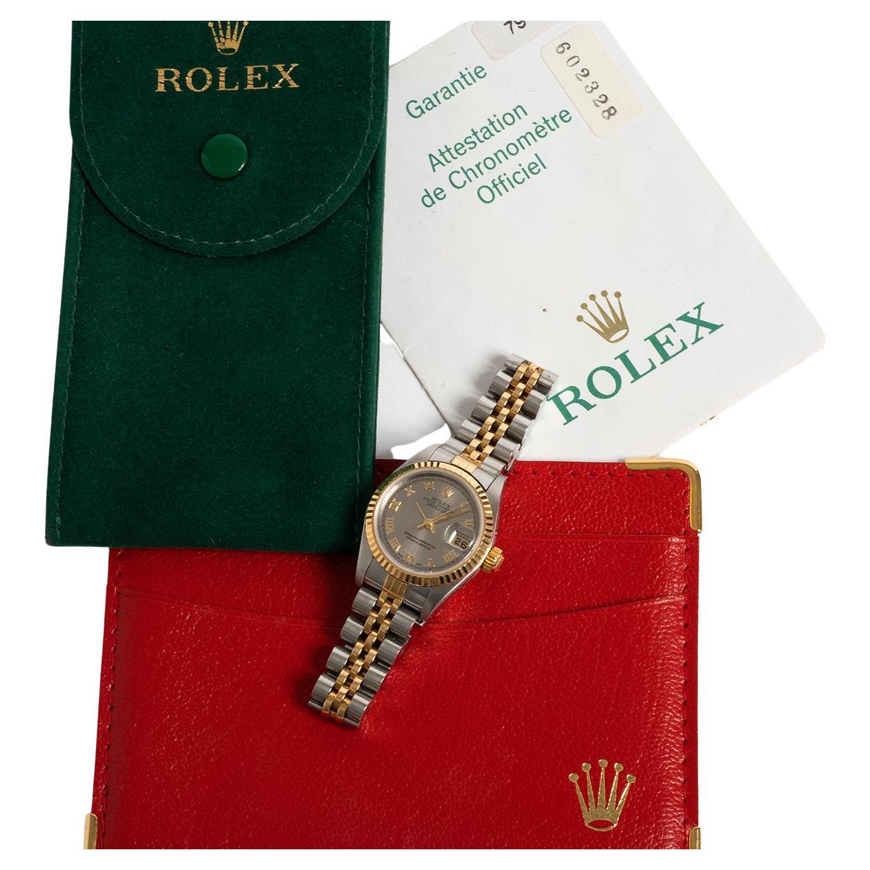 Unsere klassische Rolex Lady Datejust Referenz 79173 verfügt über ein Gehäuse aus 18 Karat Gelbgold und Edelstahl mit geriffelter Lünette und Jubiläumsarmband sowie ein seltenes rhodiumgraues Zifferblatt mit römischen Ziffern. Präsentiert in