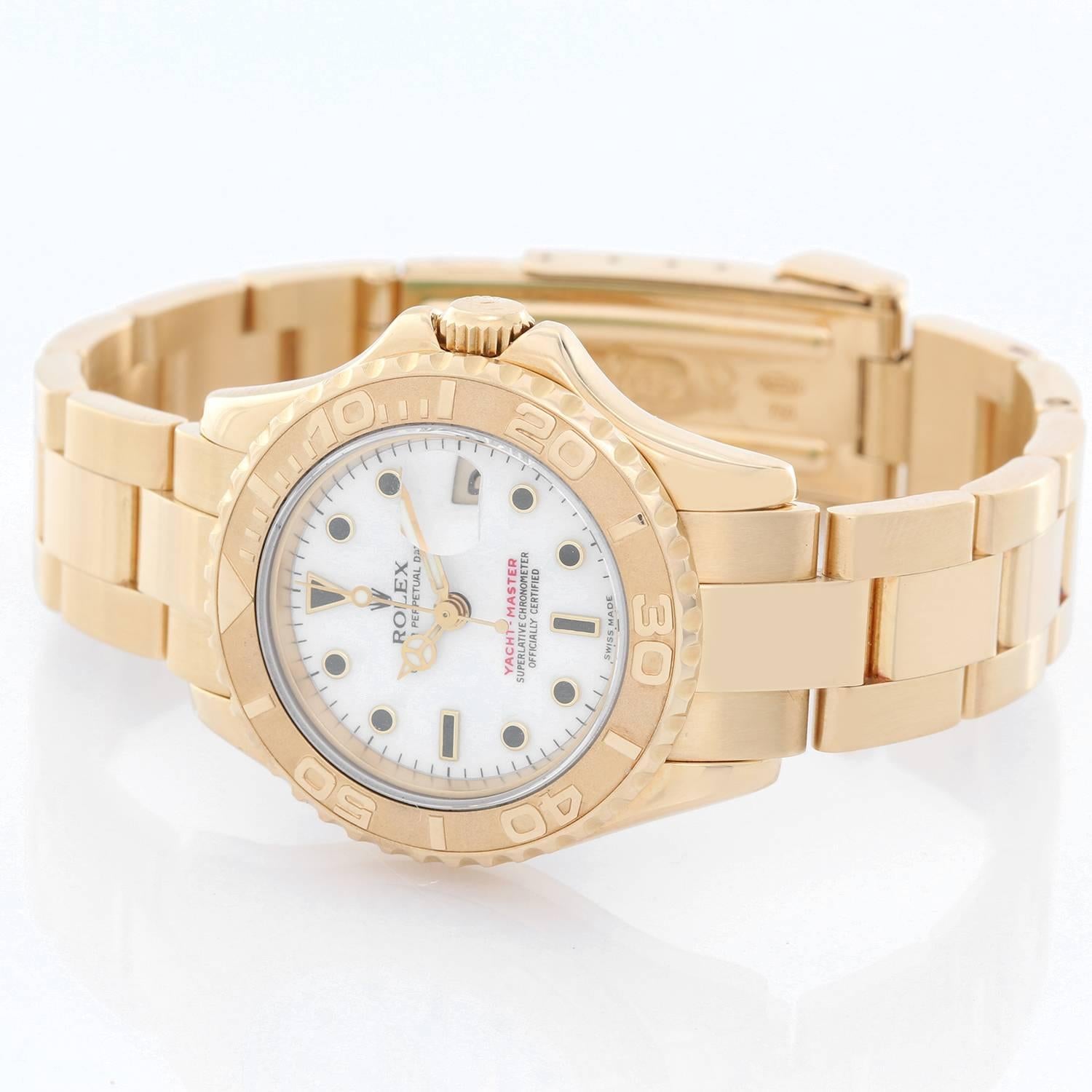 Rolex Lady Yacht-Master 18k Gold Ladies Watch 69628 -  Automatic winding, 29 jewels, Quickset date, sapphire crystal. 18k yellow gold case with rotating bezel (29mm diameter). White dial. 18k yellow gold Oyster bracelet with flip-lock clasp.