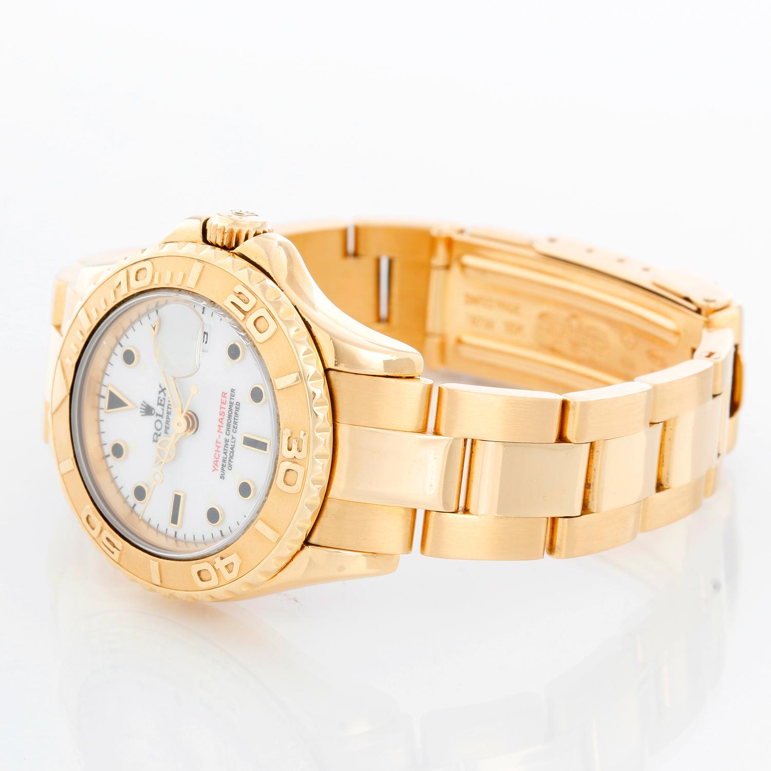 Rolex Lady Yacht-Master 18k Gold Ladies Watch 69628 - Automatic winding, 29 jewels, Quickset date, sapphire crystal. 18k yellow gold case with rotating bezel (29mm diameter). White dial. 18k yellow gold Oyster bracelet with flip-lock clasp.