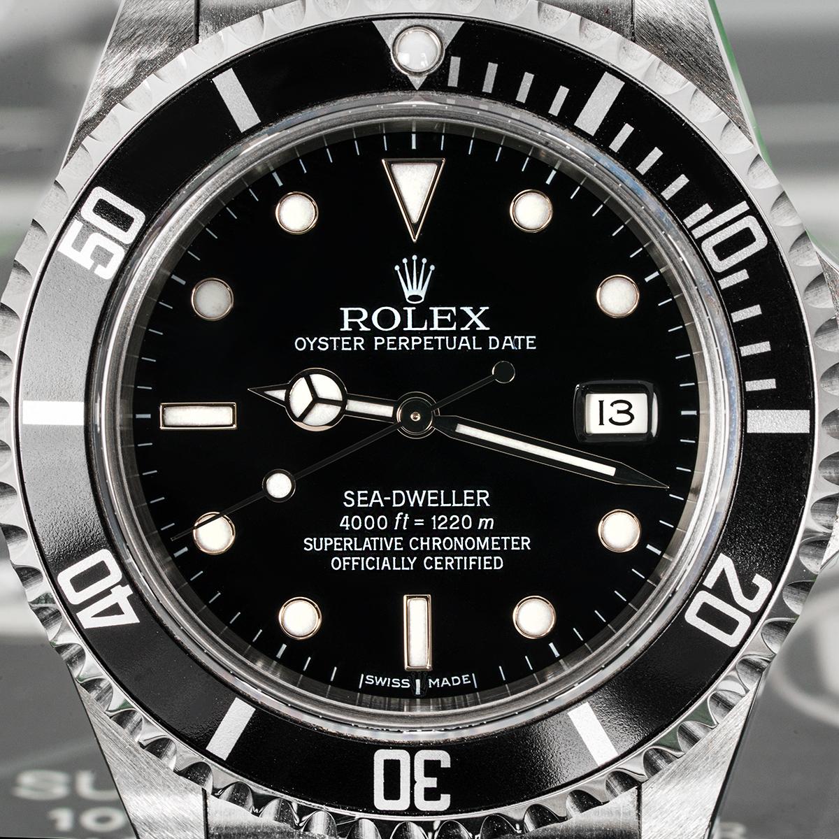 Eine NOS 40mm Sea-Dweller von Rolex. Sie verfügt über ein schwarzes Zifferblatt mit applizierten Stundenmarkierungen, eine Datumsanzeige und eine schwarze, einseitig drehbare Lünette mit 60-Minuten-Teilung.

Das Oyster-Armband ist mit einer