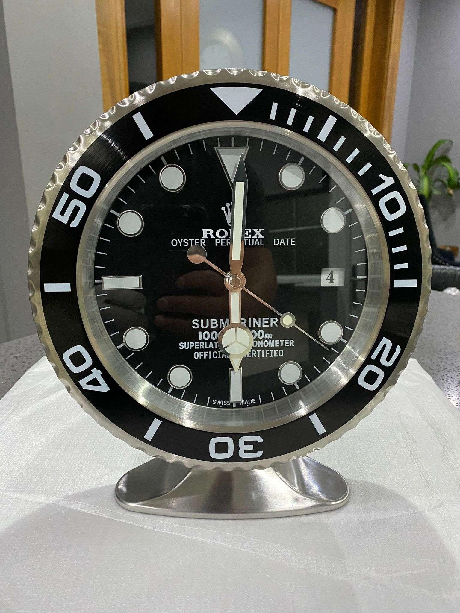 ROLEX Officially Certified Oyster Perpetual Black Submariner Desk Clock 

Luminous hands.
Fully functional date.
Sweeping hands.
Quartz movement.
Good condition, working.
Free international shipping.

These wall clocks are officially licensed by