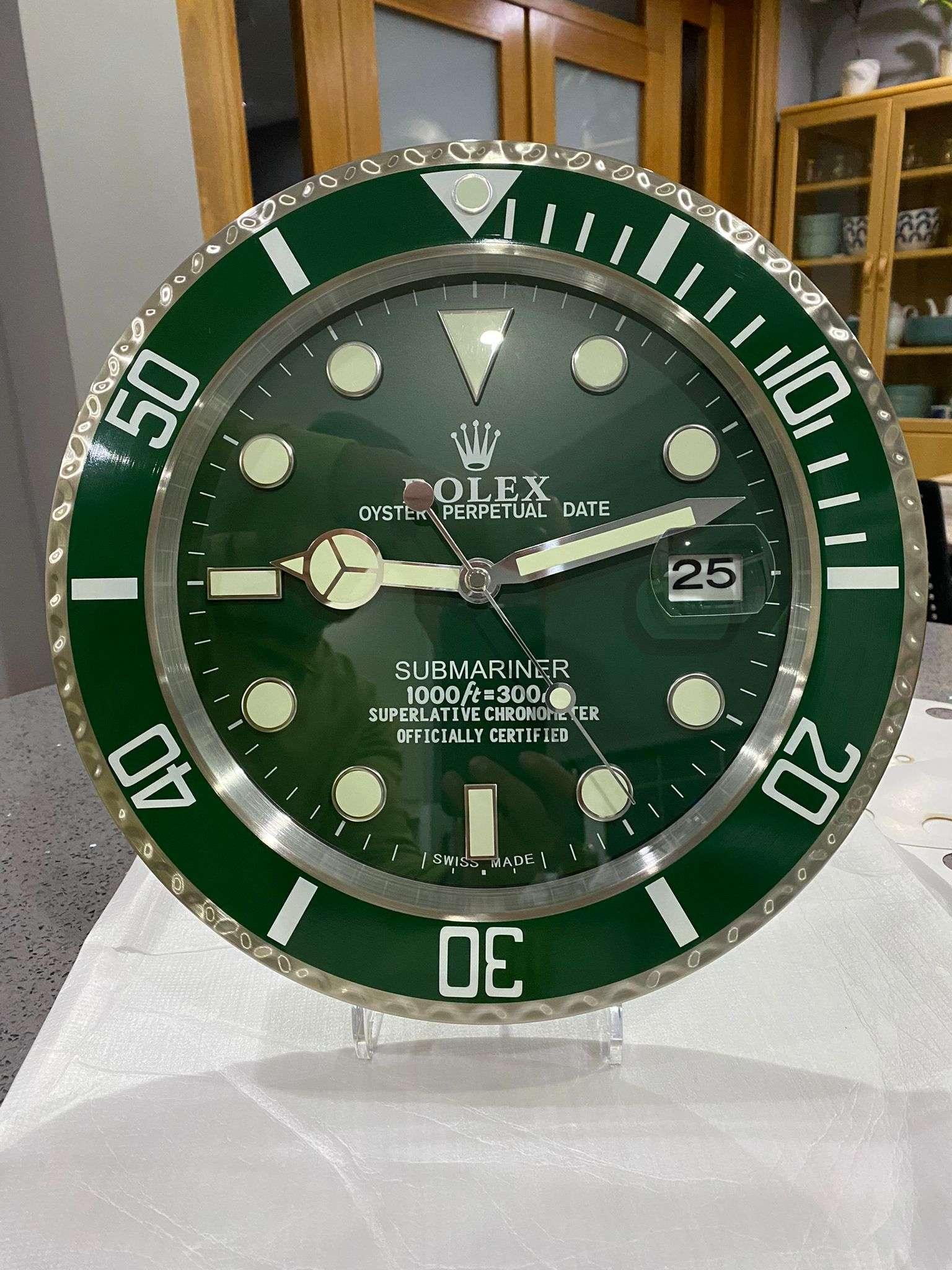 ROLEX Officially Certified Oyster Perpetual Hulk Submariner Luxury Wall Clock 
With lume strips Sweeping Quartz movement powered by single AA Battery.
Clock dimensions measure approximately 35cm by 5cm thickness Date with magnifying glass and modern