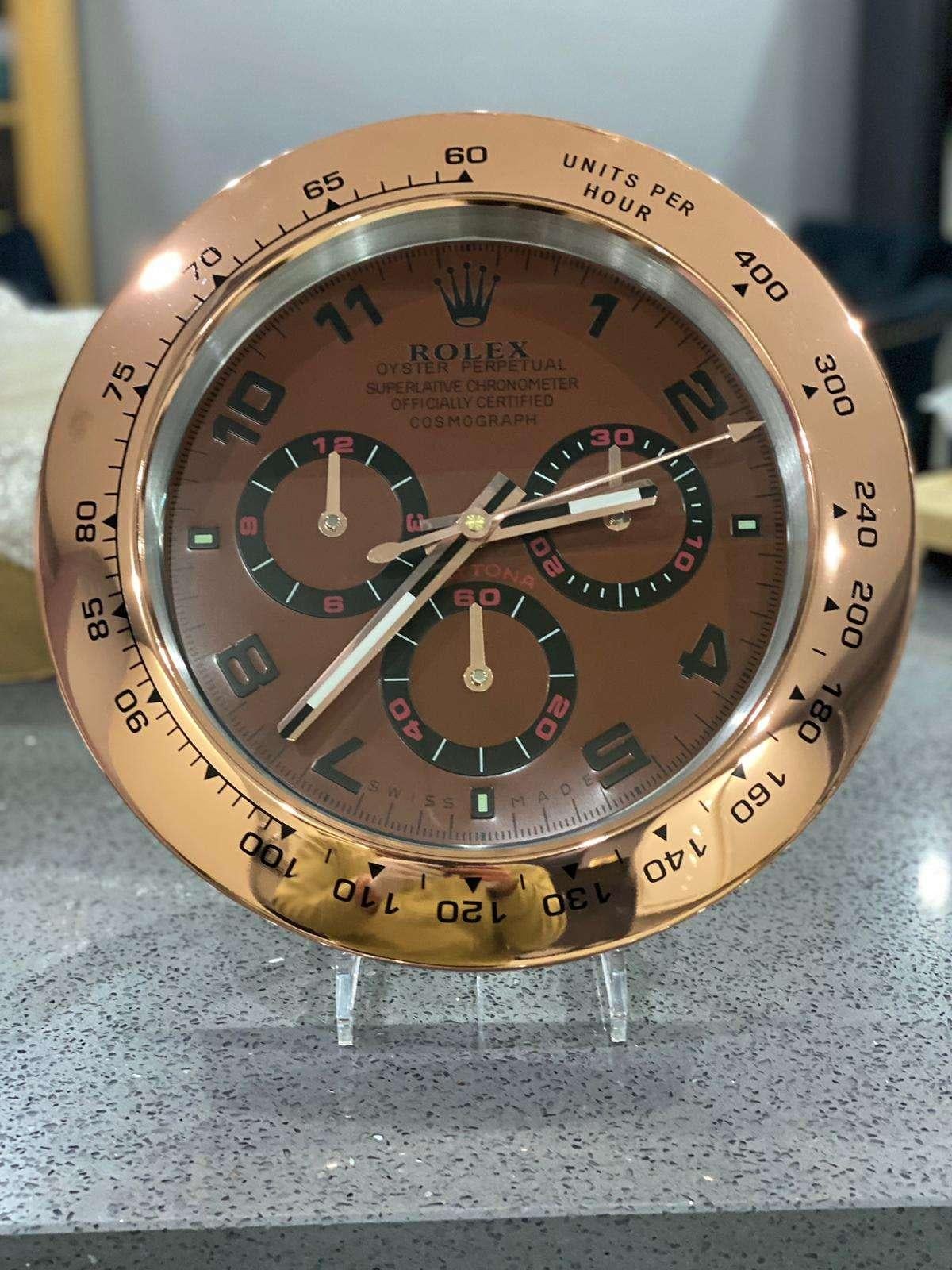 ROLEX Officially Certified Oyster Perpetual Rose Gold Chrome Wall Clock 
Good condition, working.
Lume strips Sweeping Quartz movement powered by single AA Battery.
Clock dimensions measure approximately 35cm by 5cm thickness
Free international