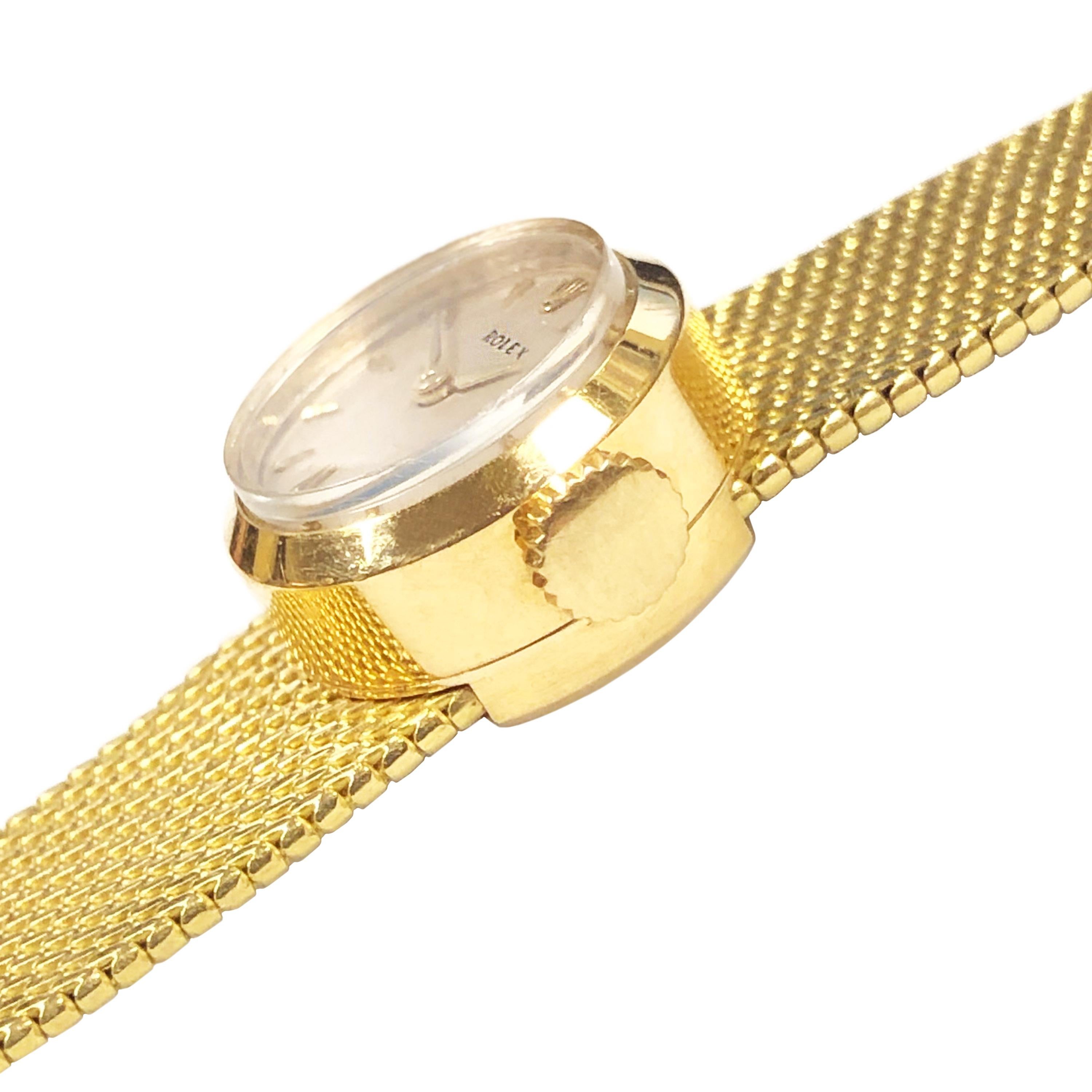 Circa 1960 Rolex Ladies Orchid Wrist Watch, 15 MM 18K Yellow Gold 2 piece case. 17 Jewel mechanical, Manual wind movement. Original Silver Dial with raised Gold markers. 1/2 inch wide Rolex signed soft mesh bracelet. The watch has a release lever on