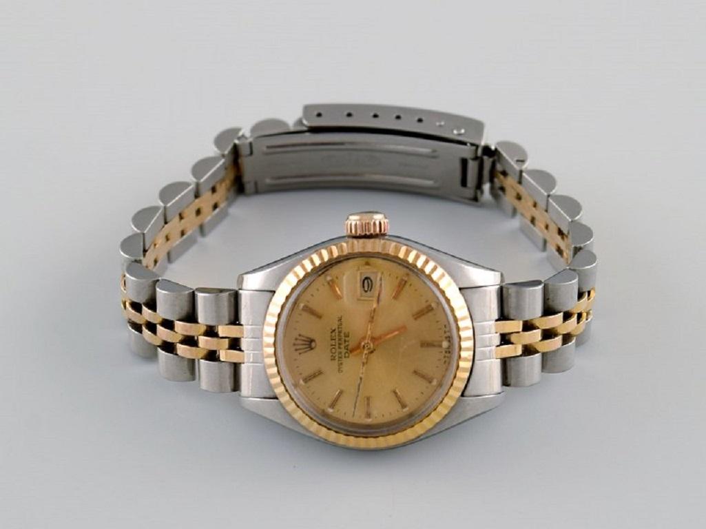 Rolex Oyster Lady Perpetual Date en or. 
Montre-bracelet pour dame, bracelet d'origine en acier bicolore et or 18 carats. 
Années 70 / 80.
Diamètre du boîtier : 26 mm.
En excellent état d'origine.
Toutes les montres sont soigneusement révisées par