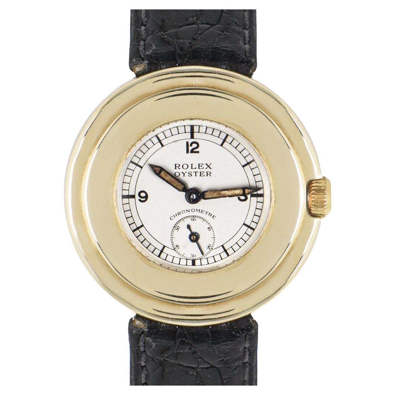 Une montre-bracelet Oyster de 32 mm assez rare en or jaune 9k, également connue sous le nom de Lifesaver par Rolex. Elle présente un petit cadran avec les chiffres arabes 12, 3, 9, un cadran auxiliaire pour la petite seconde et une large lunette