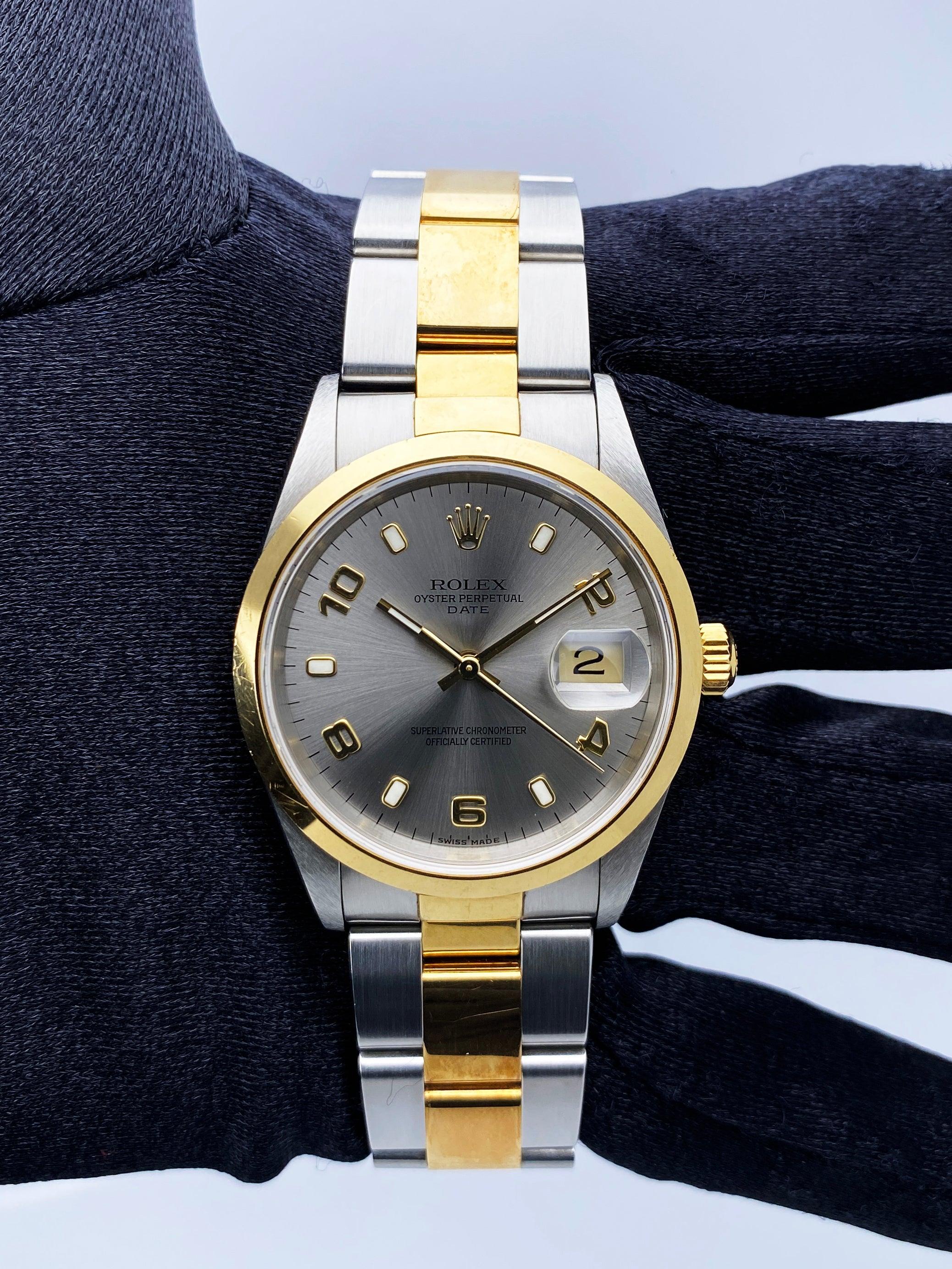 Rolex Oyster Perpetual 14203 Mens Watch. 34mm stainless steel case. 18K yellow gold smooth domed bezel. Slate dial with  luminous gold hands and Arabic numerals & index hour markers. Date display at the 3 o'clock position. Stainless steel and 18K
